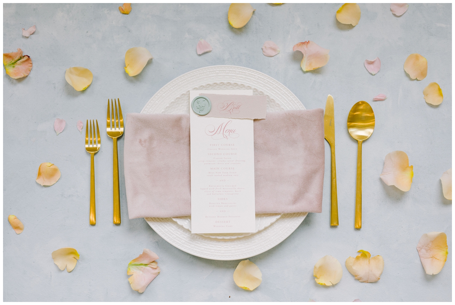 white and gold place setting with pink linen and white menu card inside Brighton Abbey