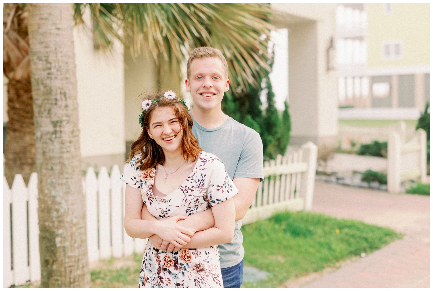 engaged couple standing under palm tree in Galveston, Texas
