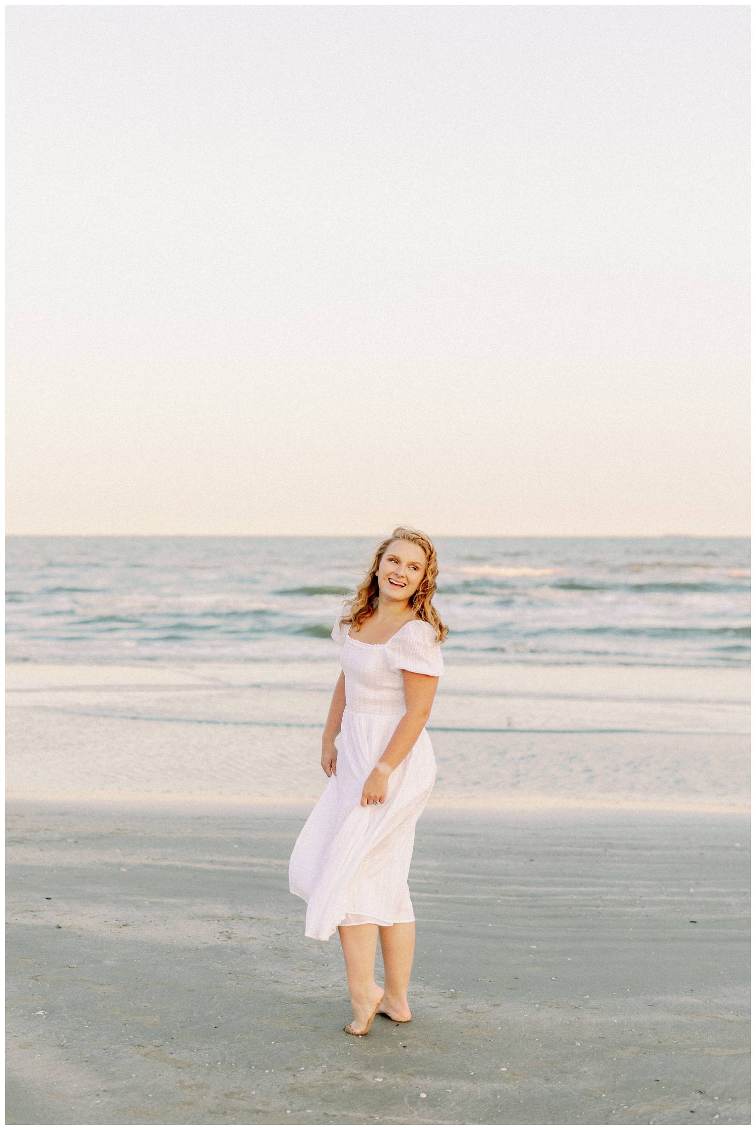 girl in white dress laughing on the beach in Galveston, Texas