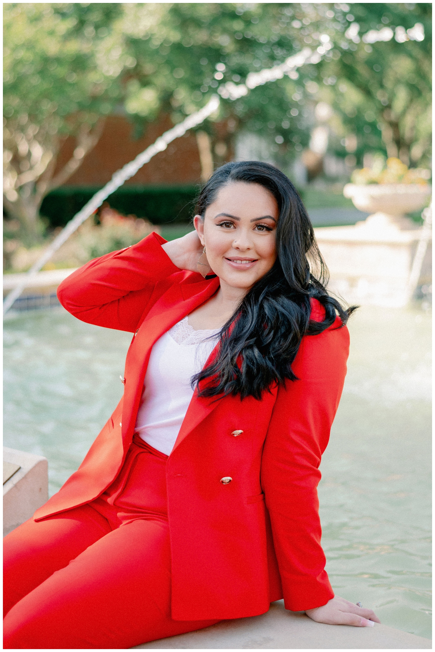 girl sitting by a fountain in a red suit