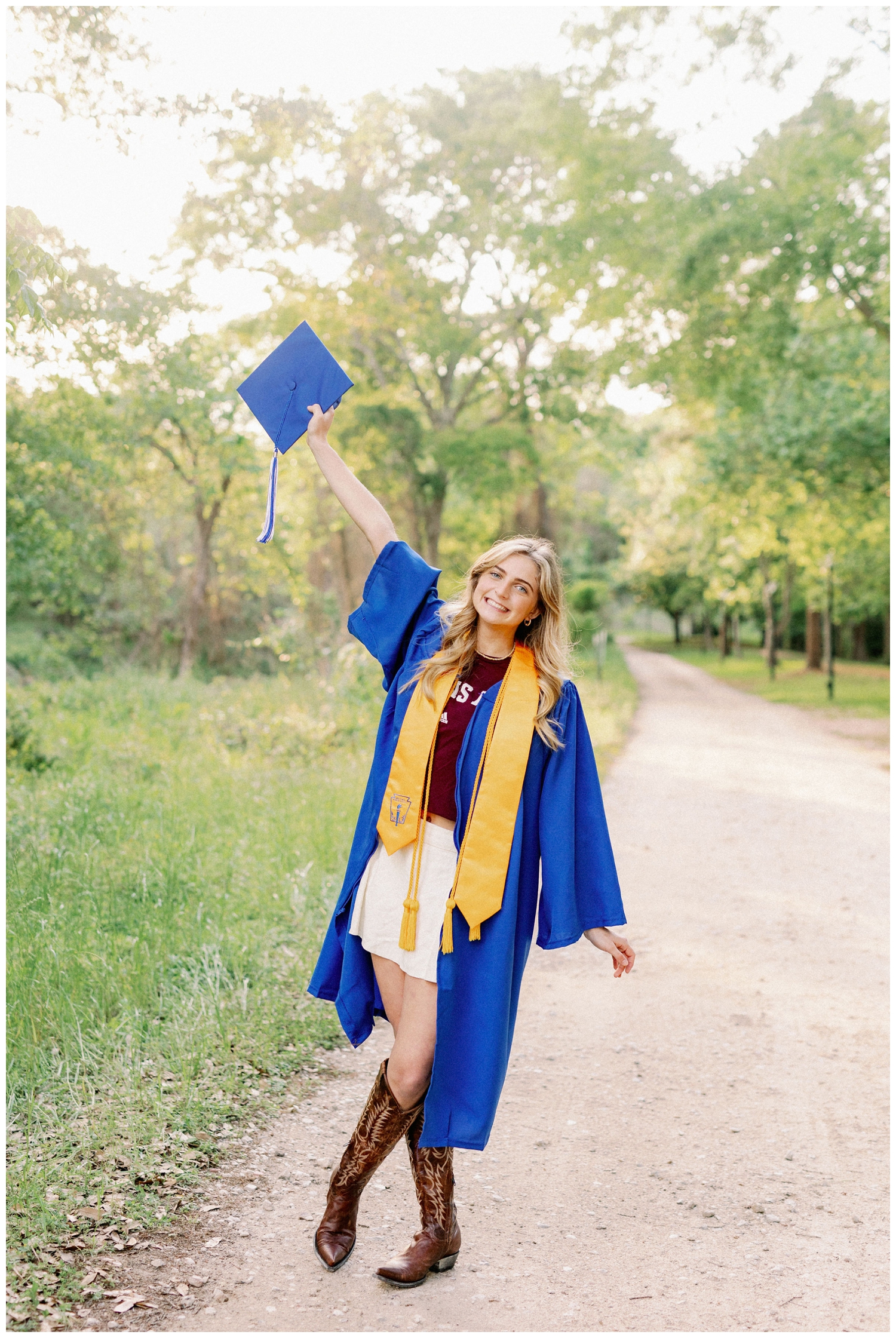 girl holding grad cap in the air for cap and gown portrait