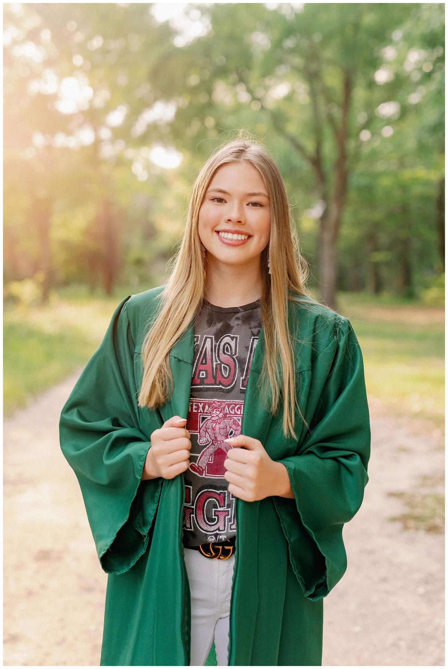 girl standing sidewalk in emerald green graduation gown