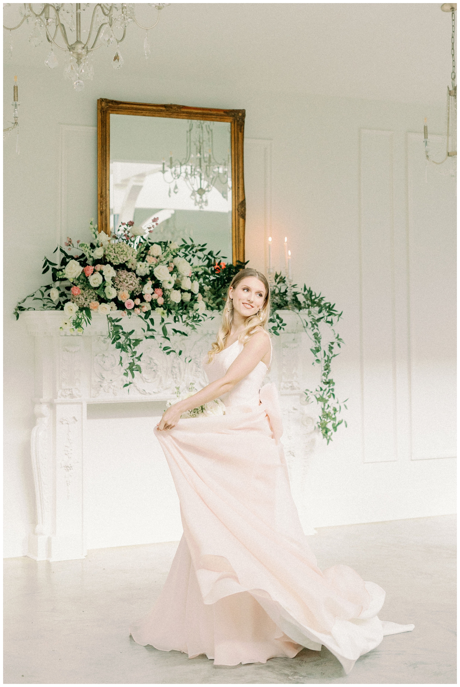 bride twirling wedding dress in front of floral display on a mantle