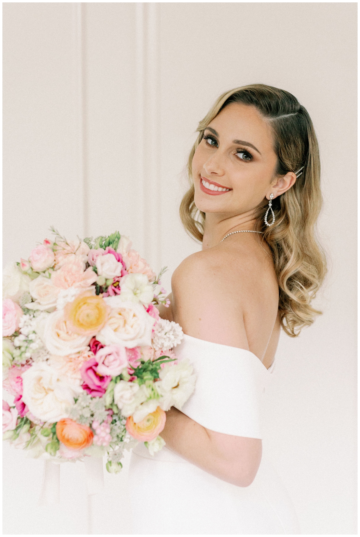 bride holding bright floral bouquet smiling