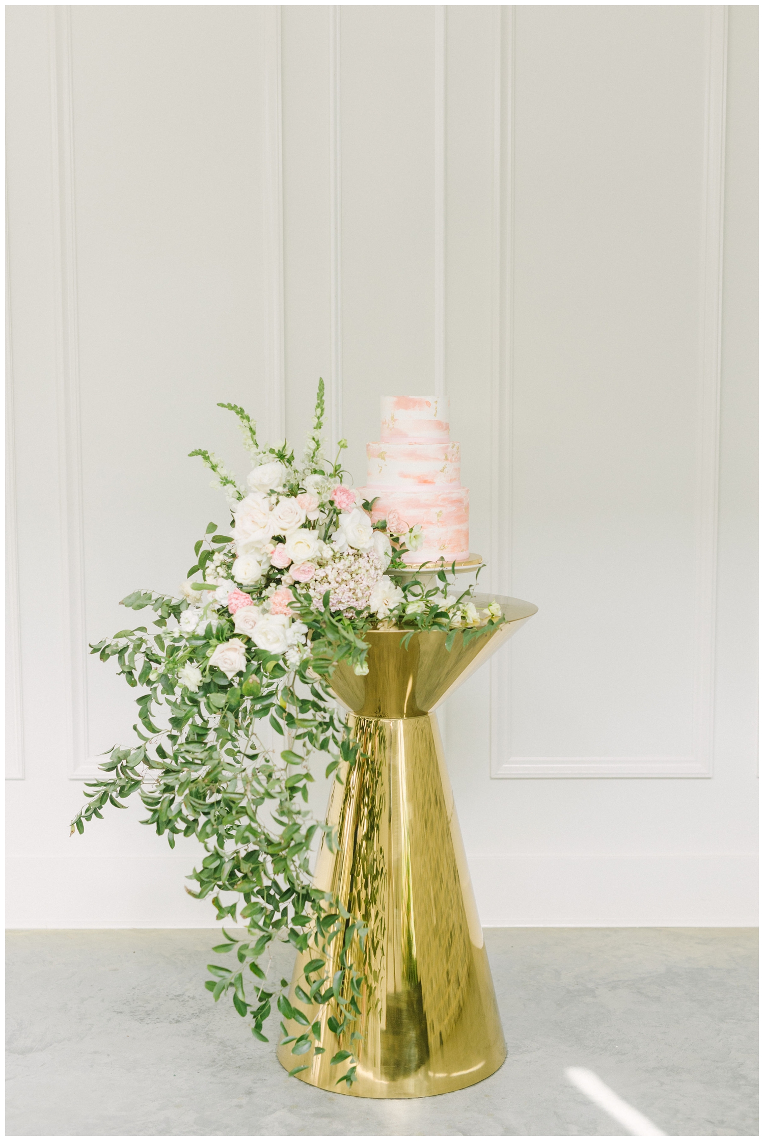 gold cocktail table with white and pink cake and florals at The Peach Orchard