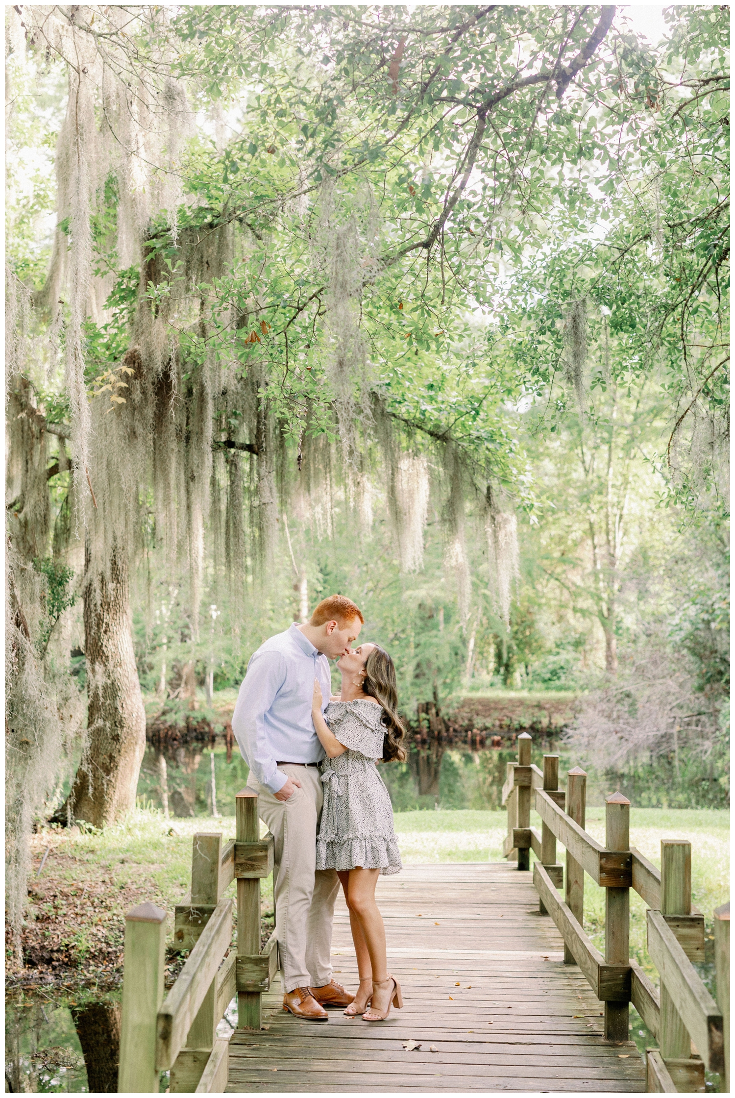 couple looking at each other under mossy trees on a bridge in Cypress Texas