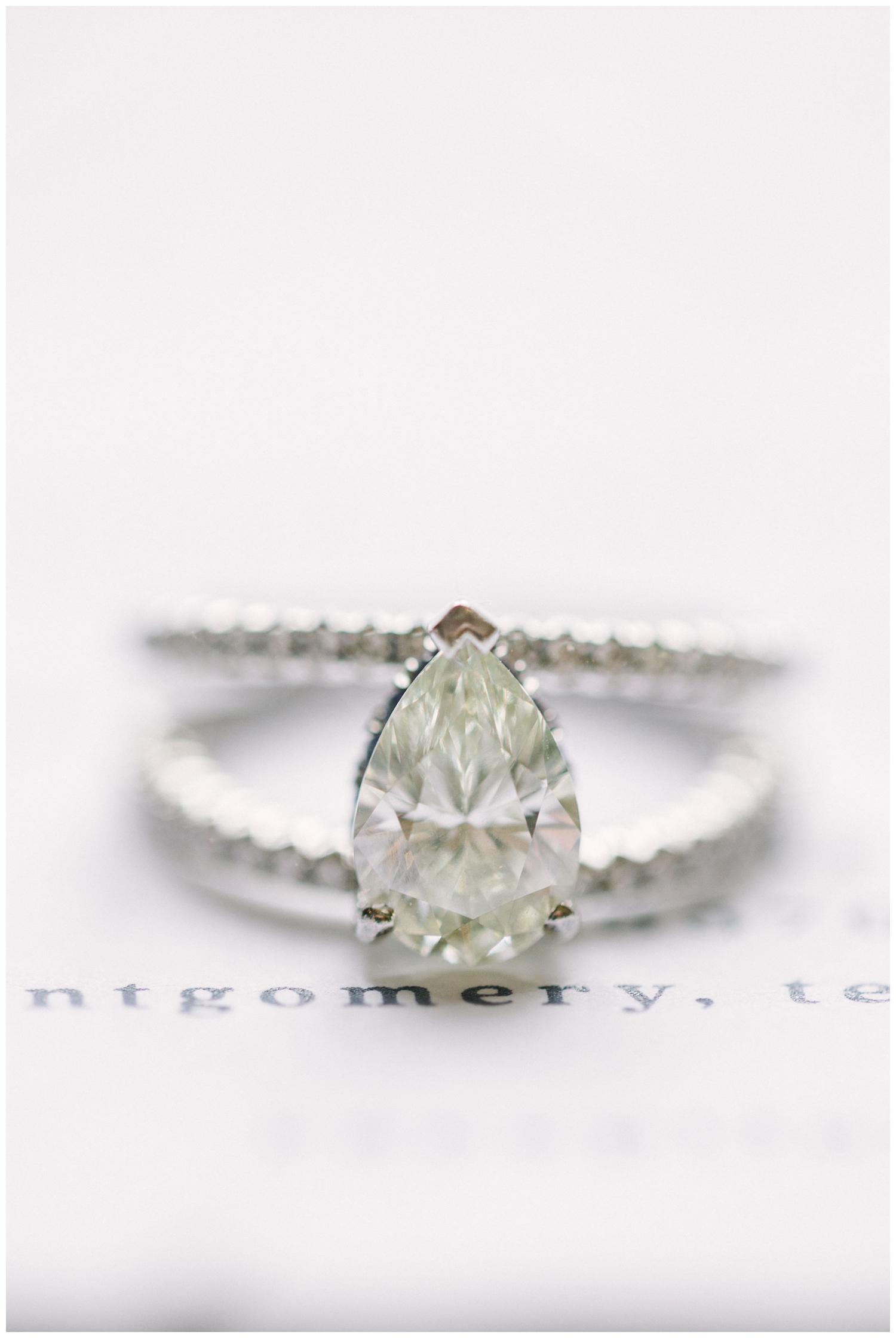 teardrop diamond ring on white invitation