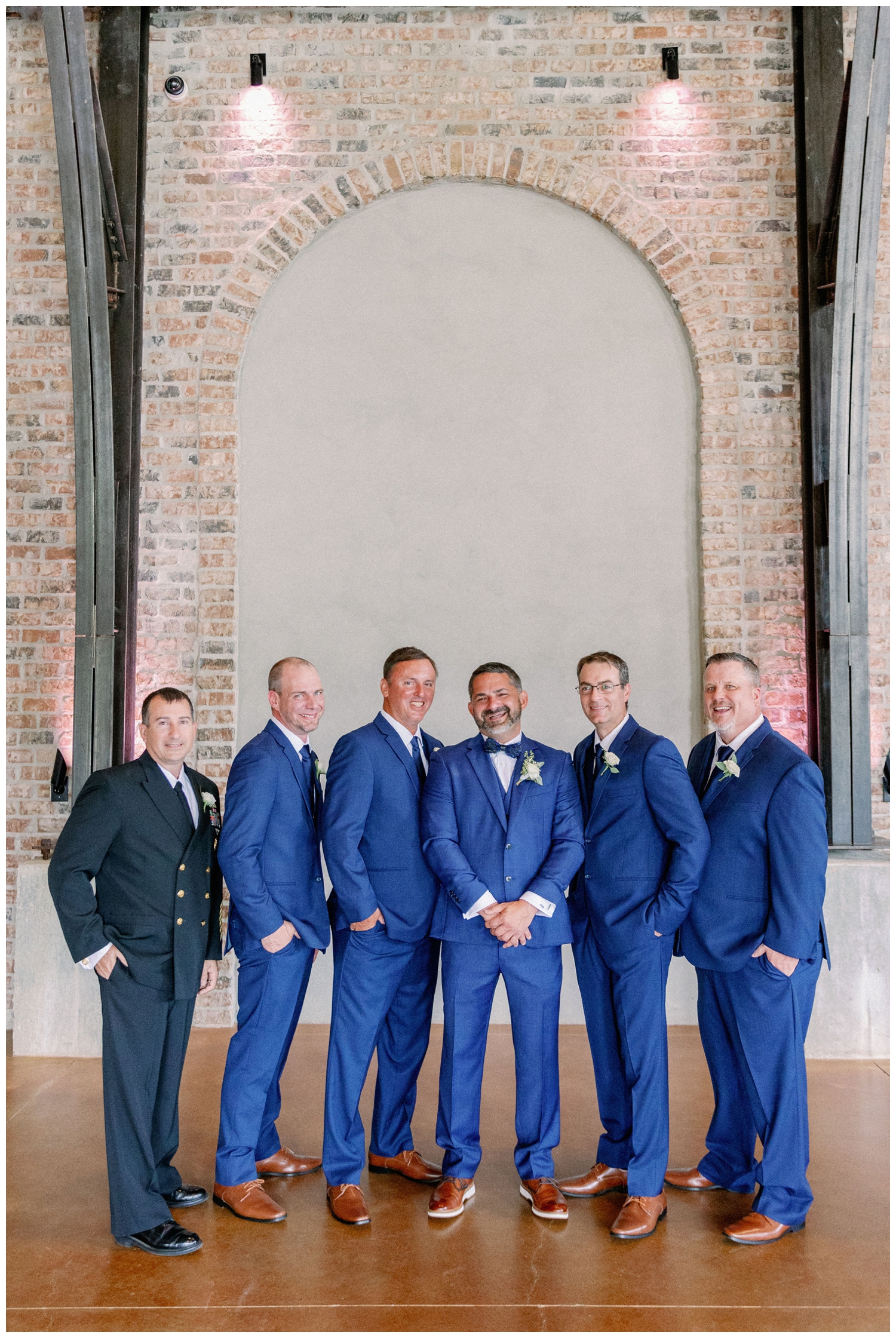 groom and groomsmen in blue suits standing
