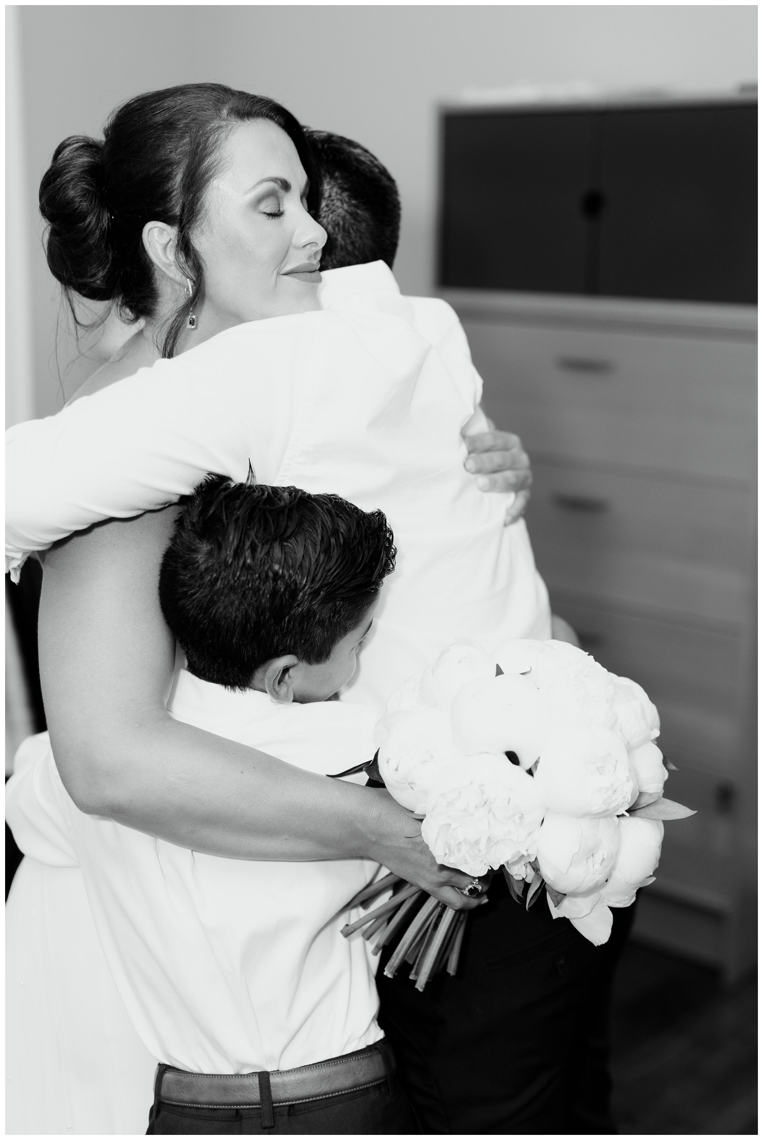 black and white photo of bride hugging her children