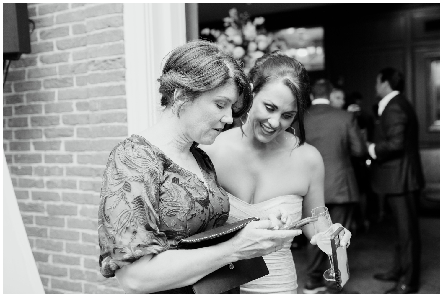 black and white candid of bride with a guest