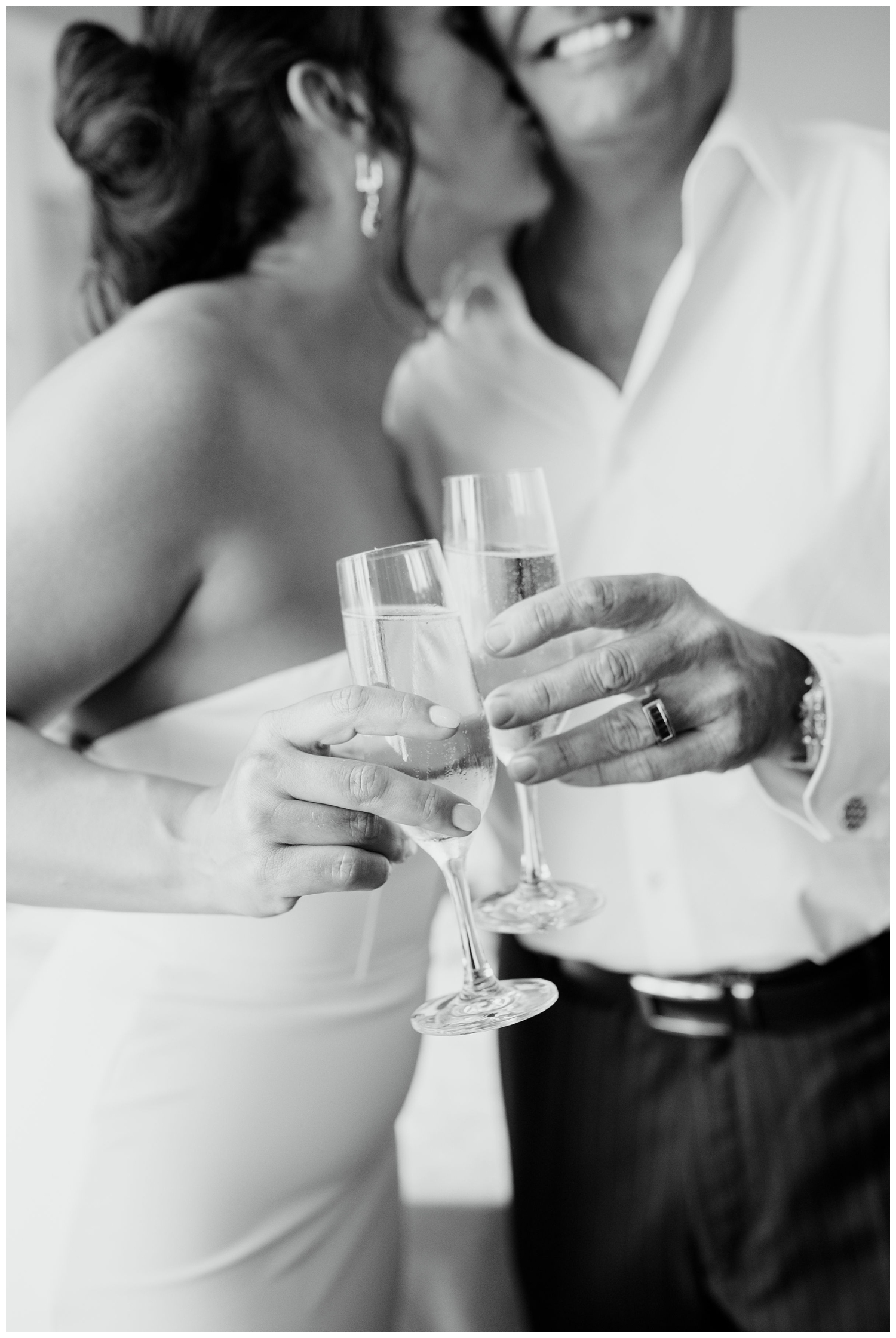 black and white photo of bride and groom toasting champagne