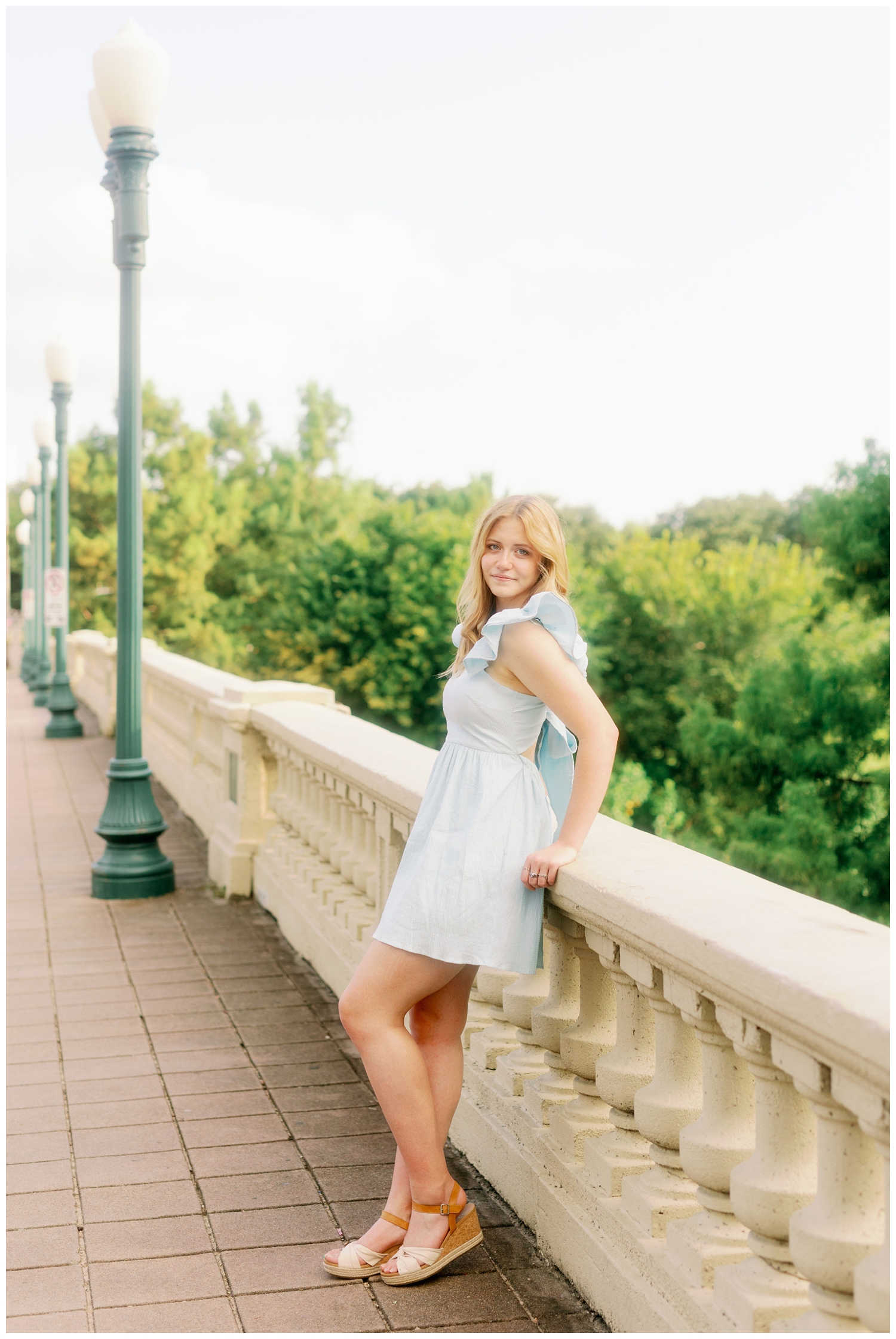 girl in blue dress leaning on Sabine bridge