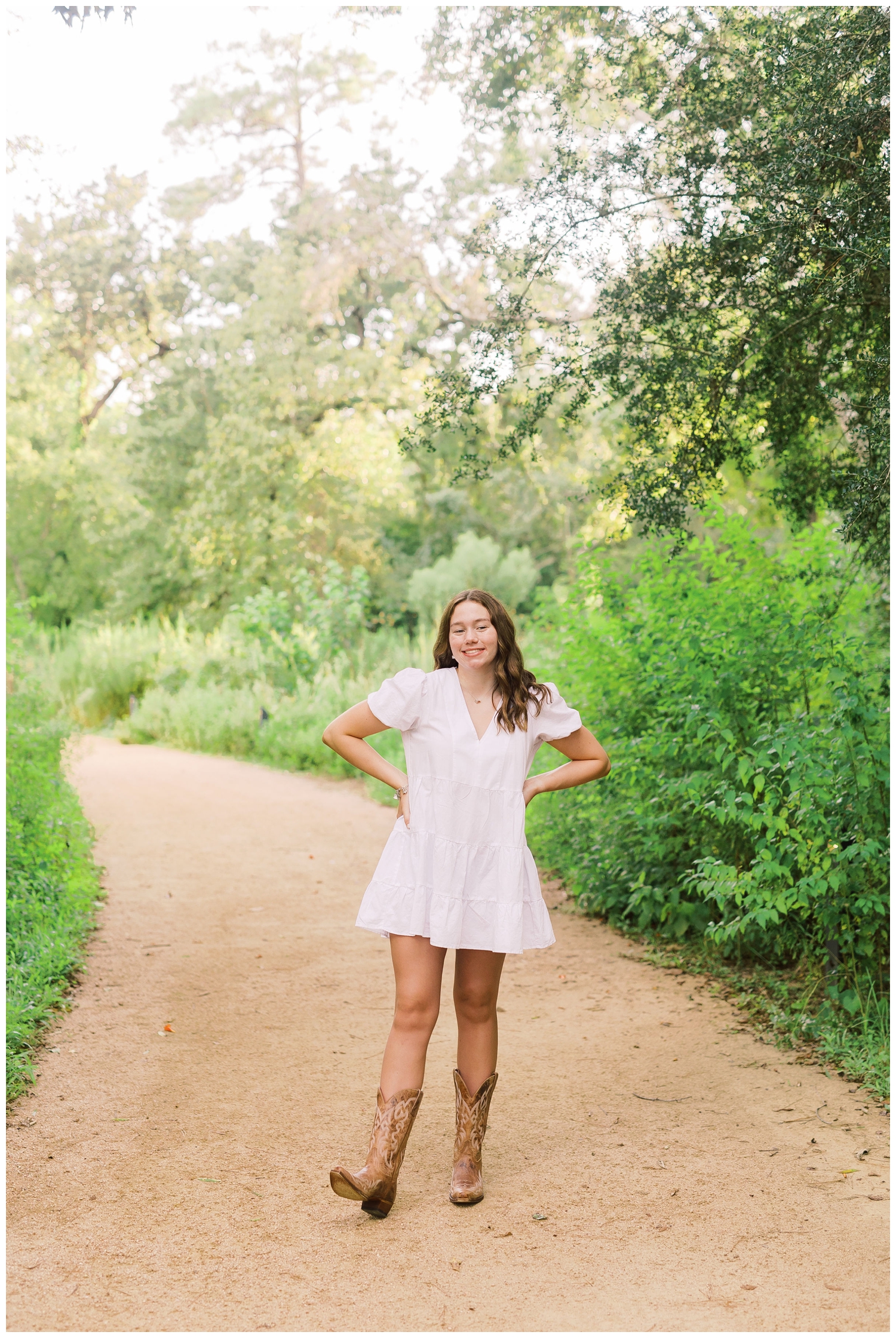 Houston senior photos with girl in white sundress and cowboy boots at Houston Arboretum
