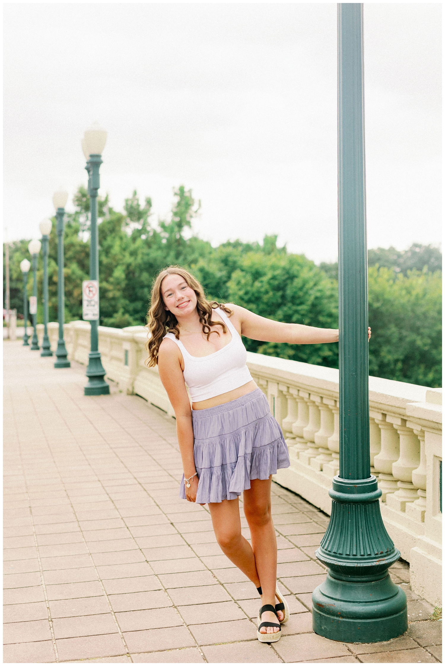 girl leaning on green lamp post at Sabine Bridge in Buffalo Bayou