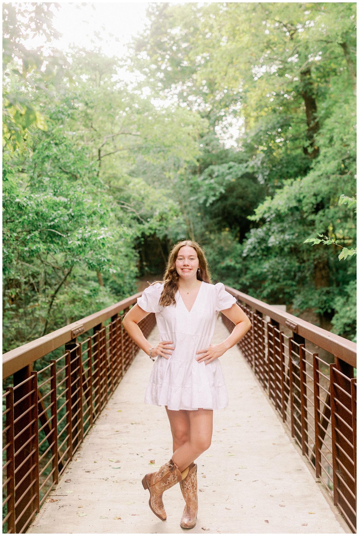 girl standing on bridge at Houston Arboretum in cowboy boots