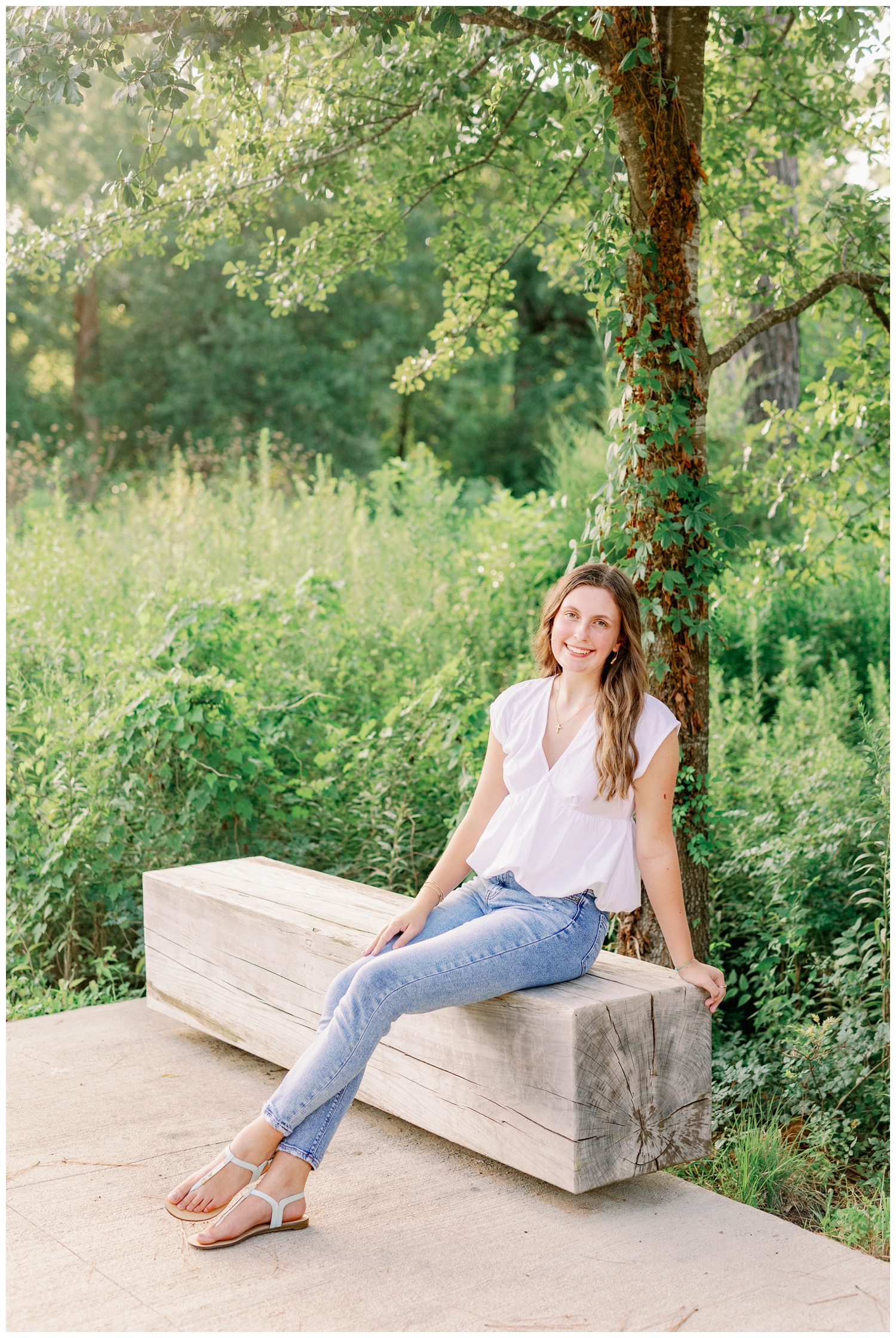 girl sitting on bench in jeans and white shirt at Houston Arboretum