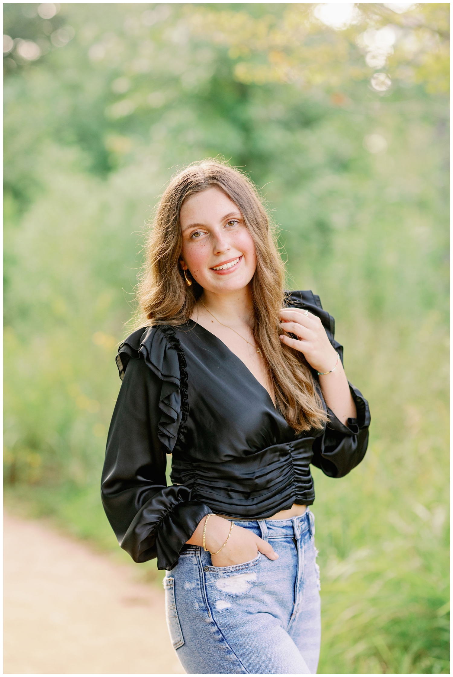 senior portrait girl in black shirt outside by a field