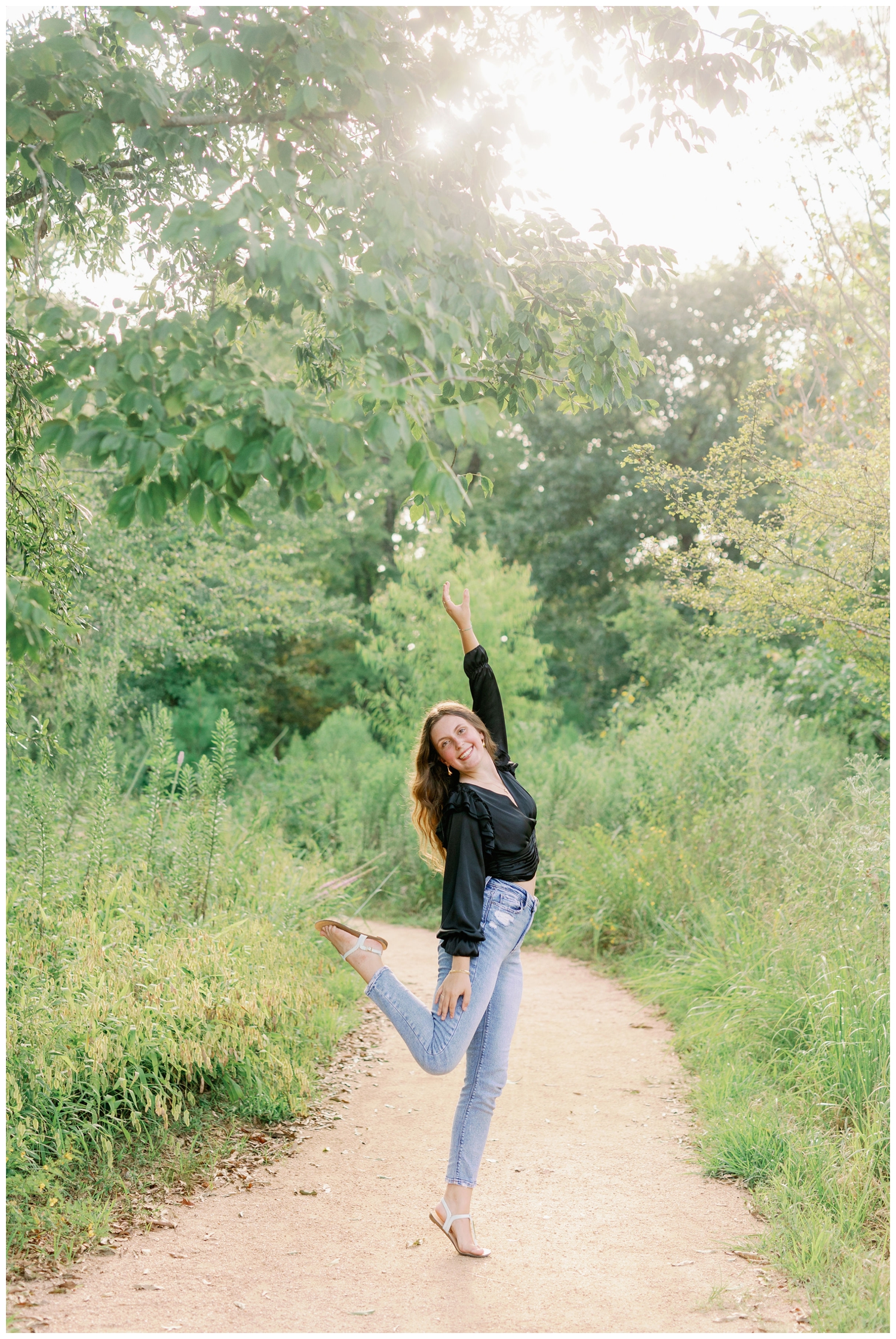senior girl Kinkaid School doing a kick on a path Senior photography Houston Arboretum