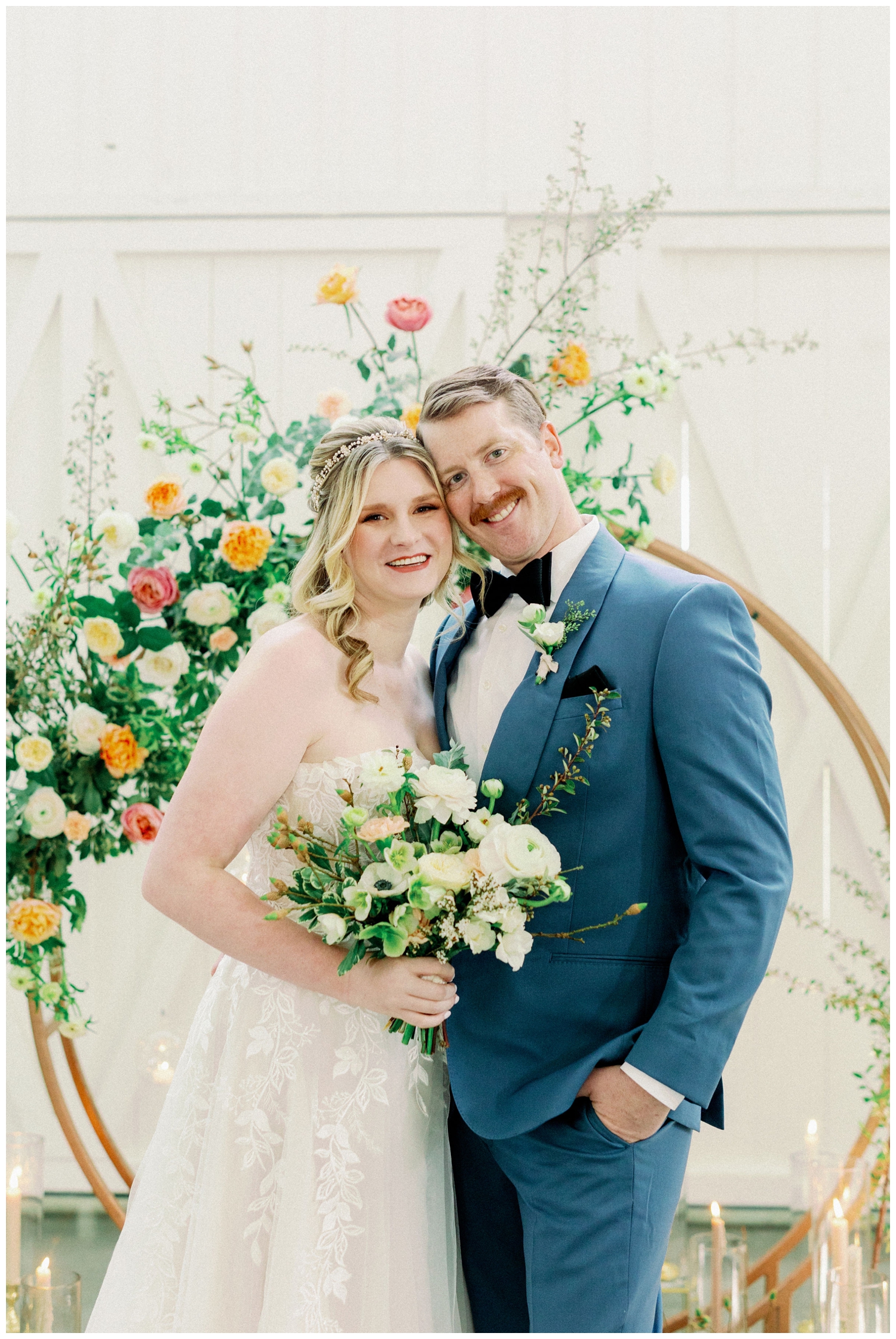 bride and groom portrait with bright florals on a gold hoop at The Farmhouse Wedding and Event Venue