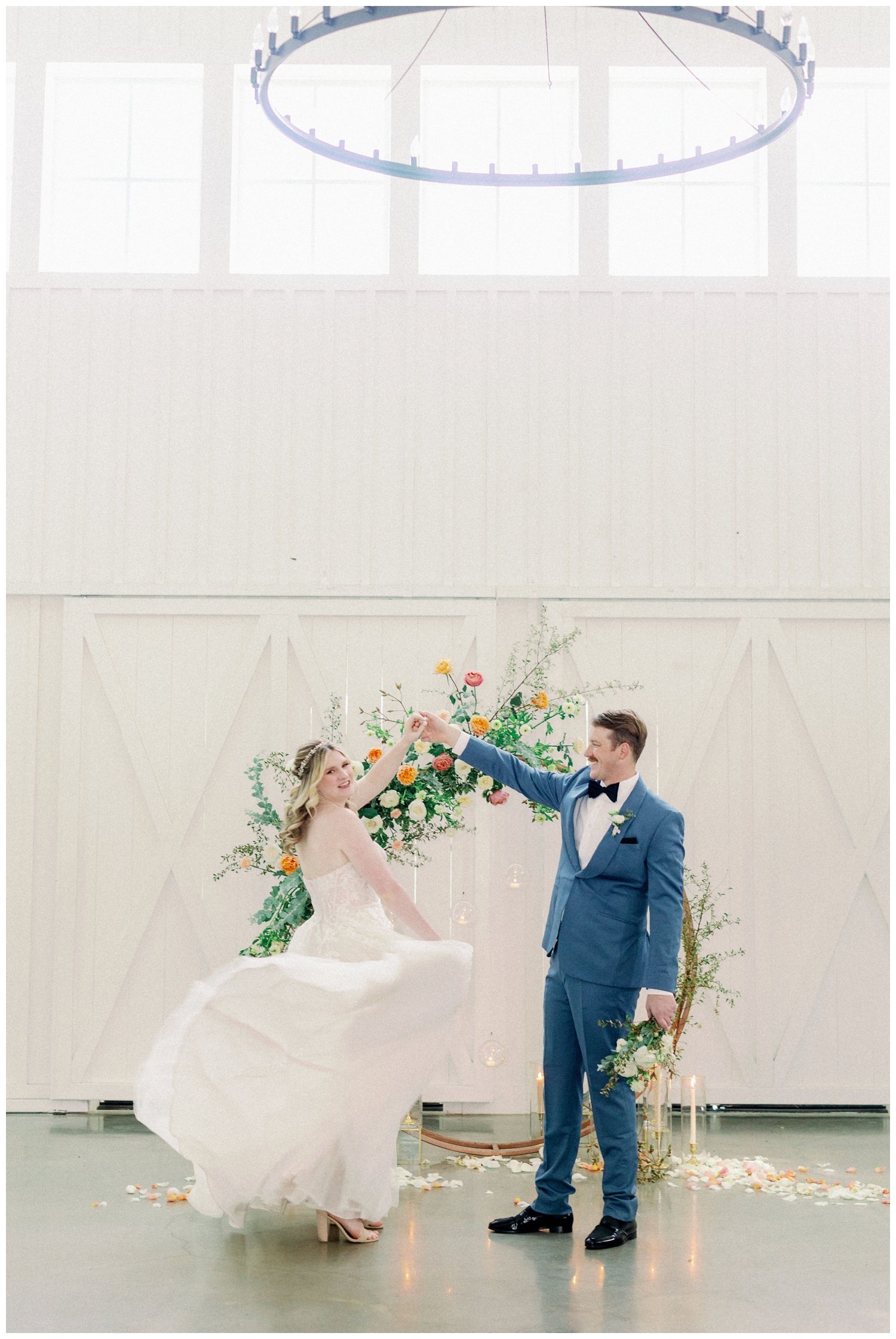 groom twirling bride inside white barn reception space in Montgomery, Texas