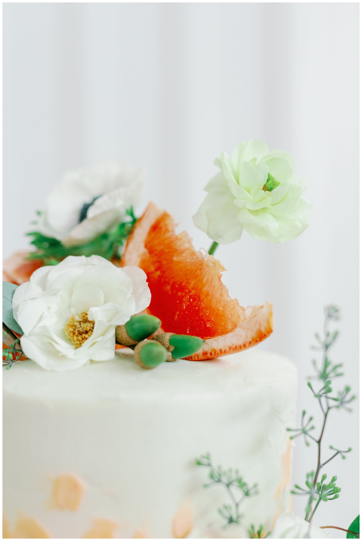 closeup of grapefruit on white wedding cake inside he Farmhouse Wedding and Event Venue in Montgomery, Texas