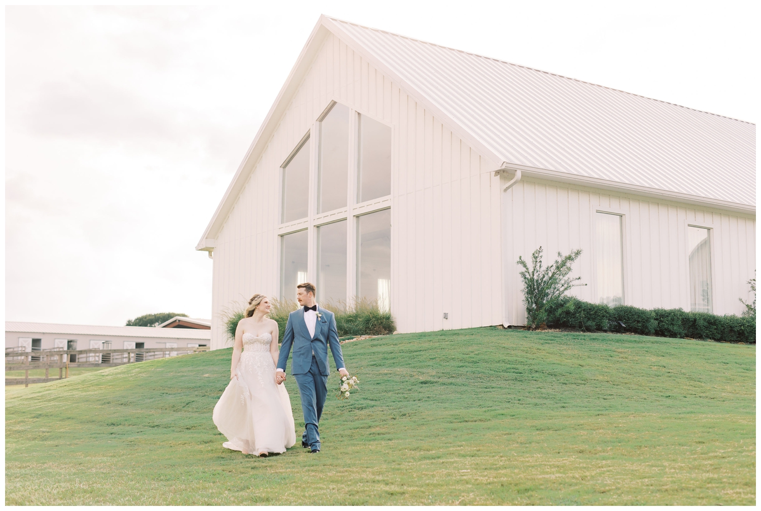 bride and groom holding hands and walking outside of chapel on lawn of The Farmhouse Wedding and Event Venue
