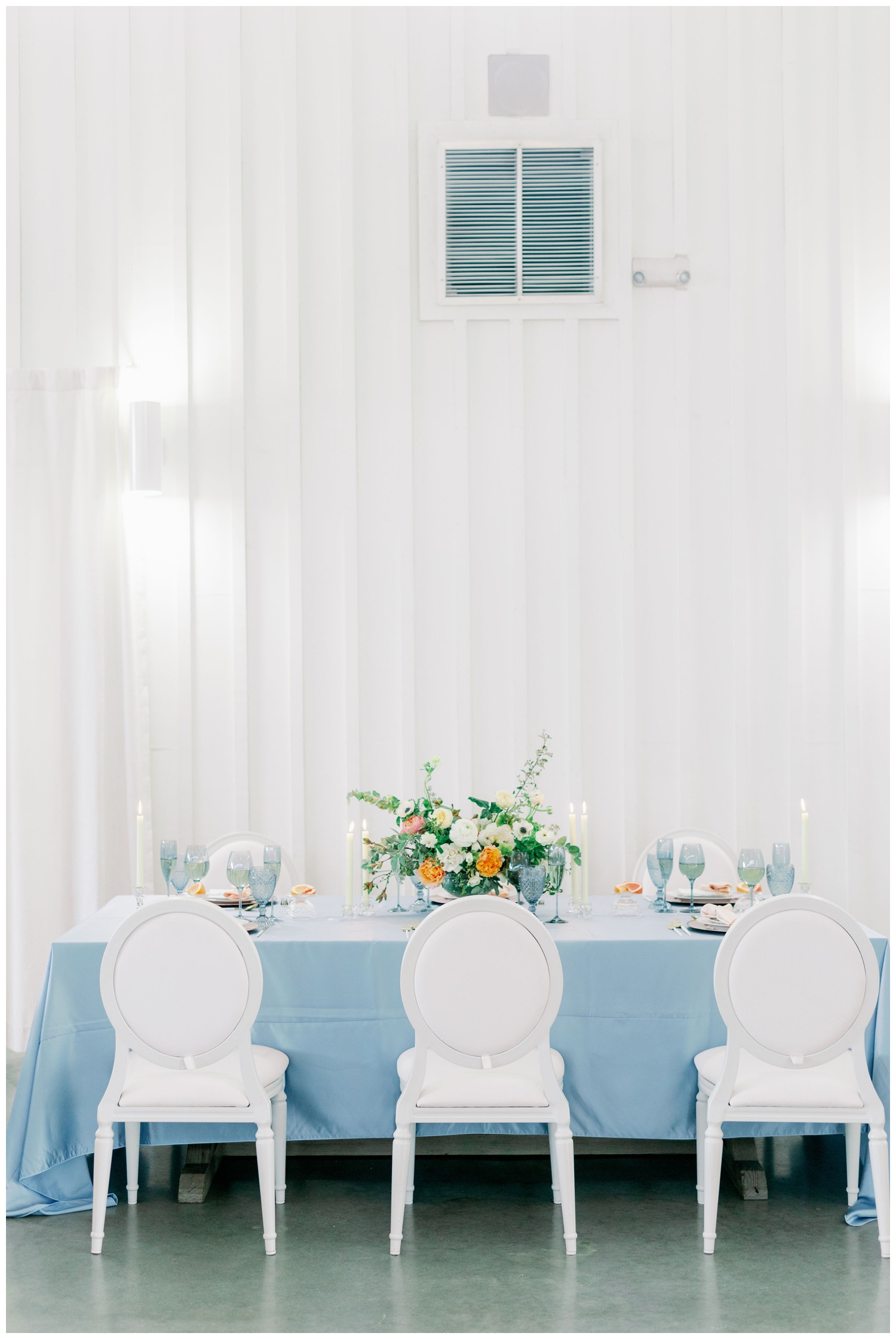 light blue reception table with white chairs inside he Farmhouse Wedding and Event Venue