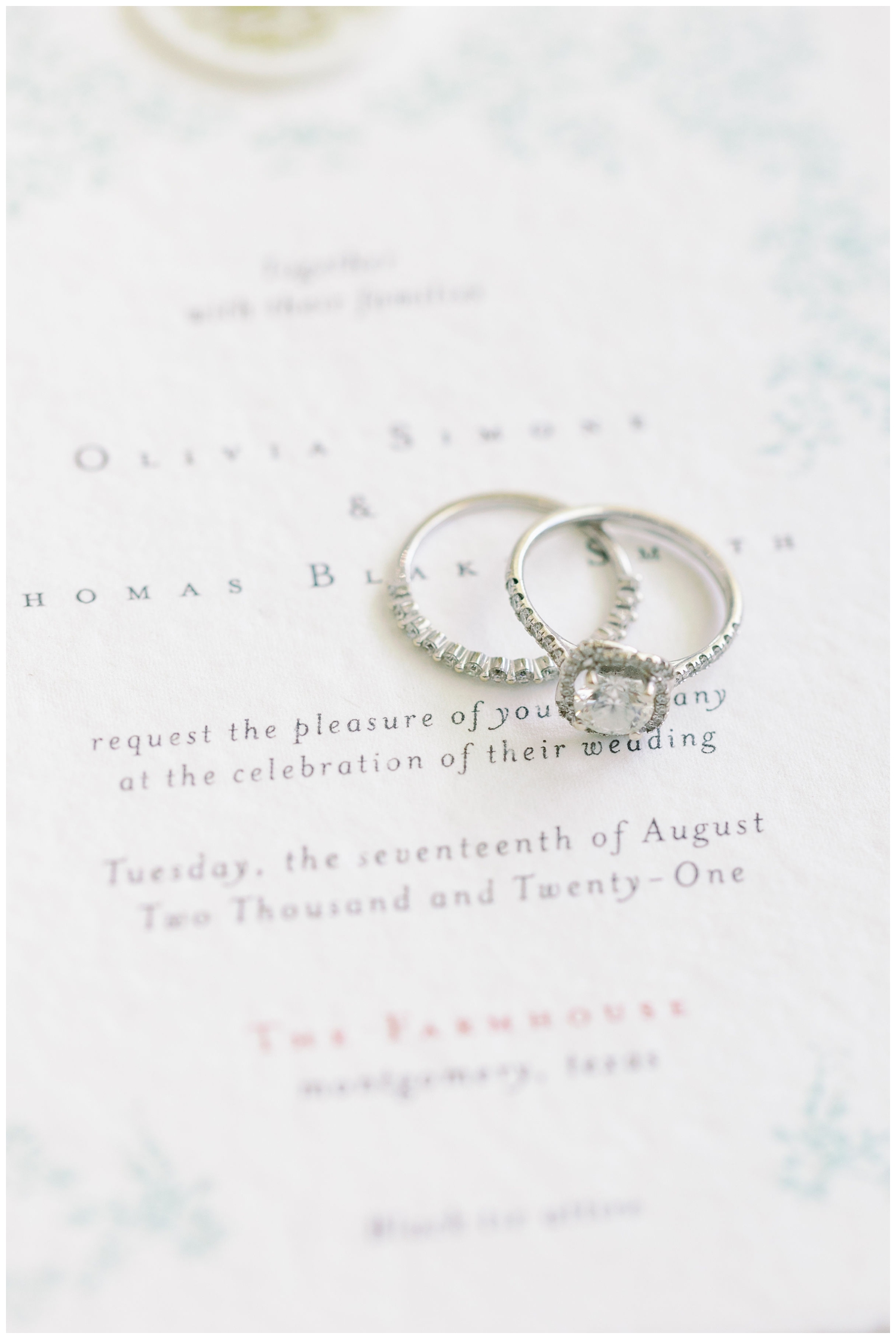 silver wedding rings on white invitation