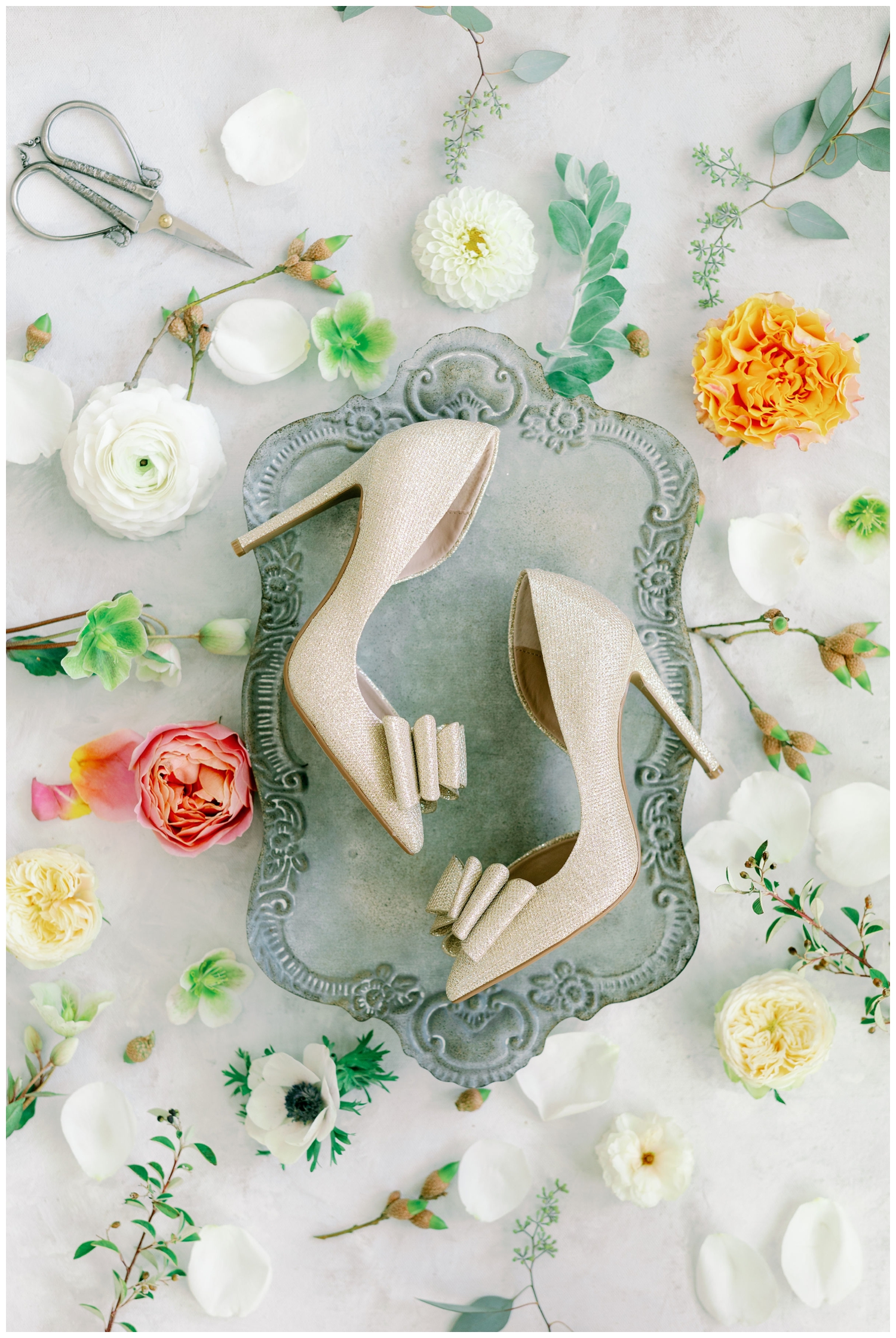 cream shoes on a silver tray surrounded with florals