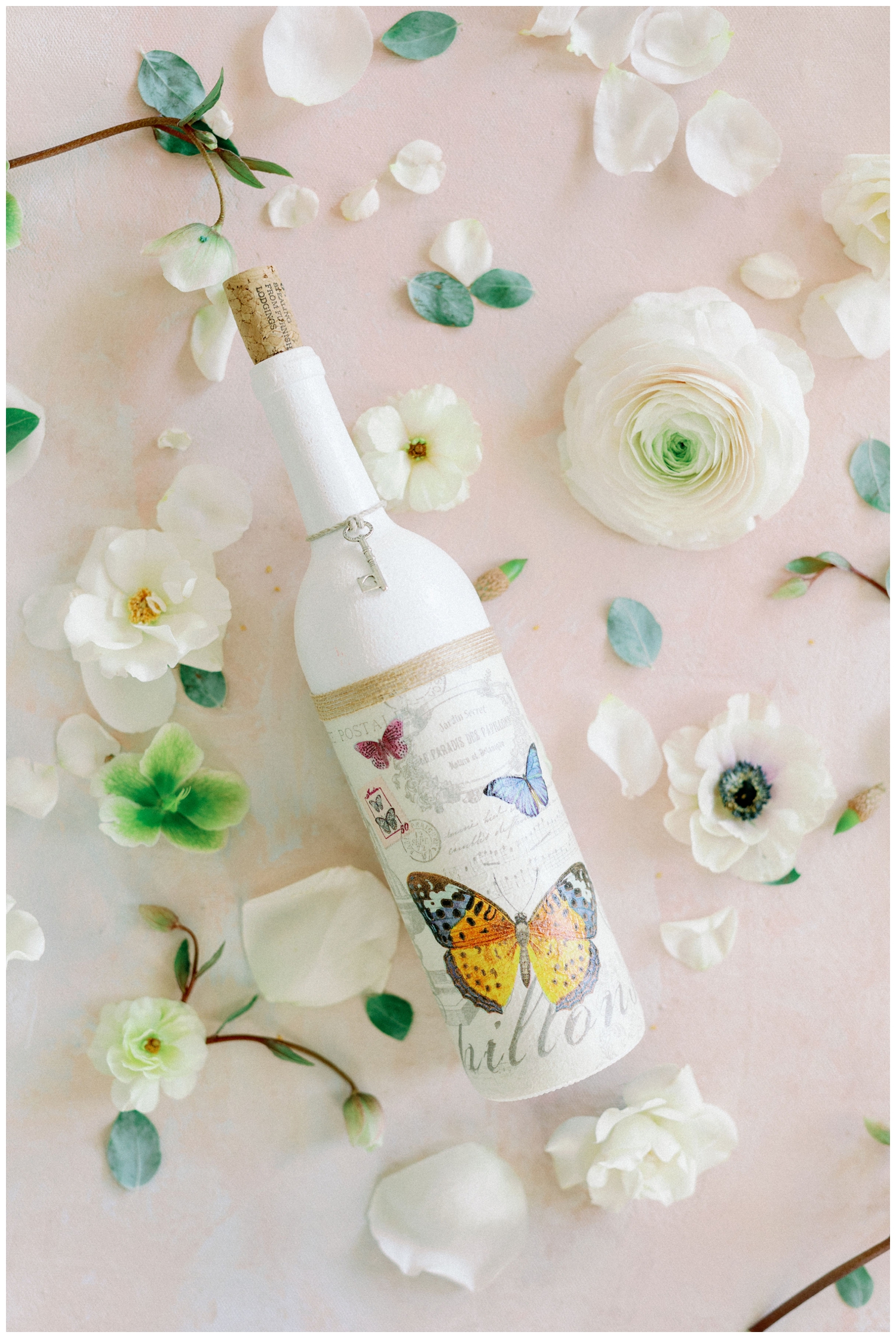white wine bottle with butterfly and florals flatlay editorial at The Farmhouse in Montgomery, Texas