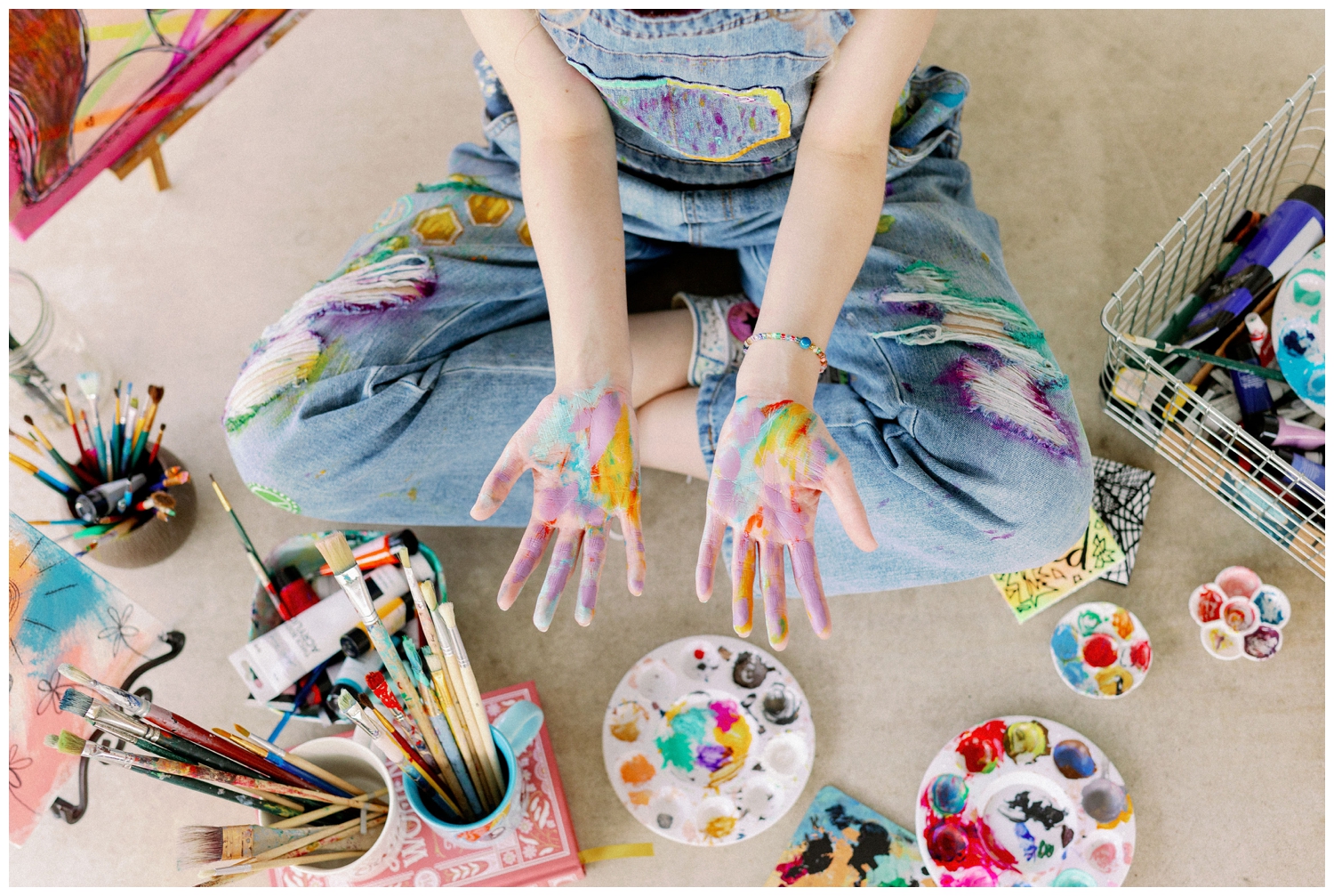 colorful Houston senior photos with girl seated in with painted hands