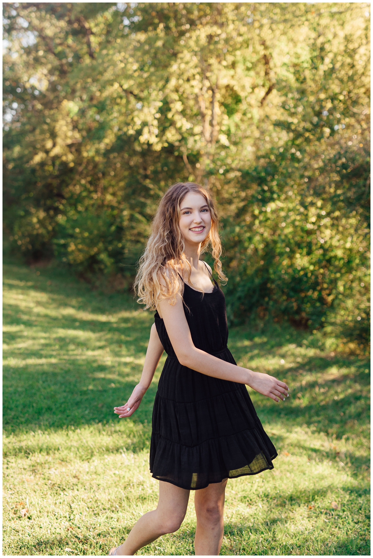 senior girl in black sundress twirling outdoors Houston