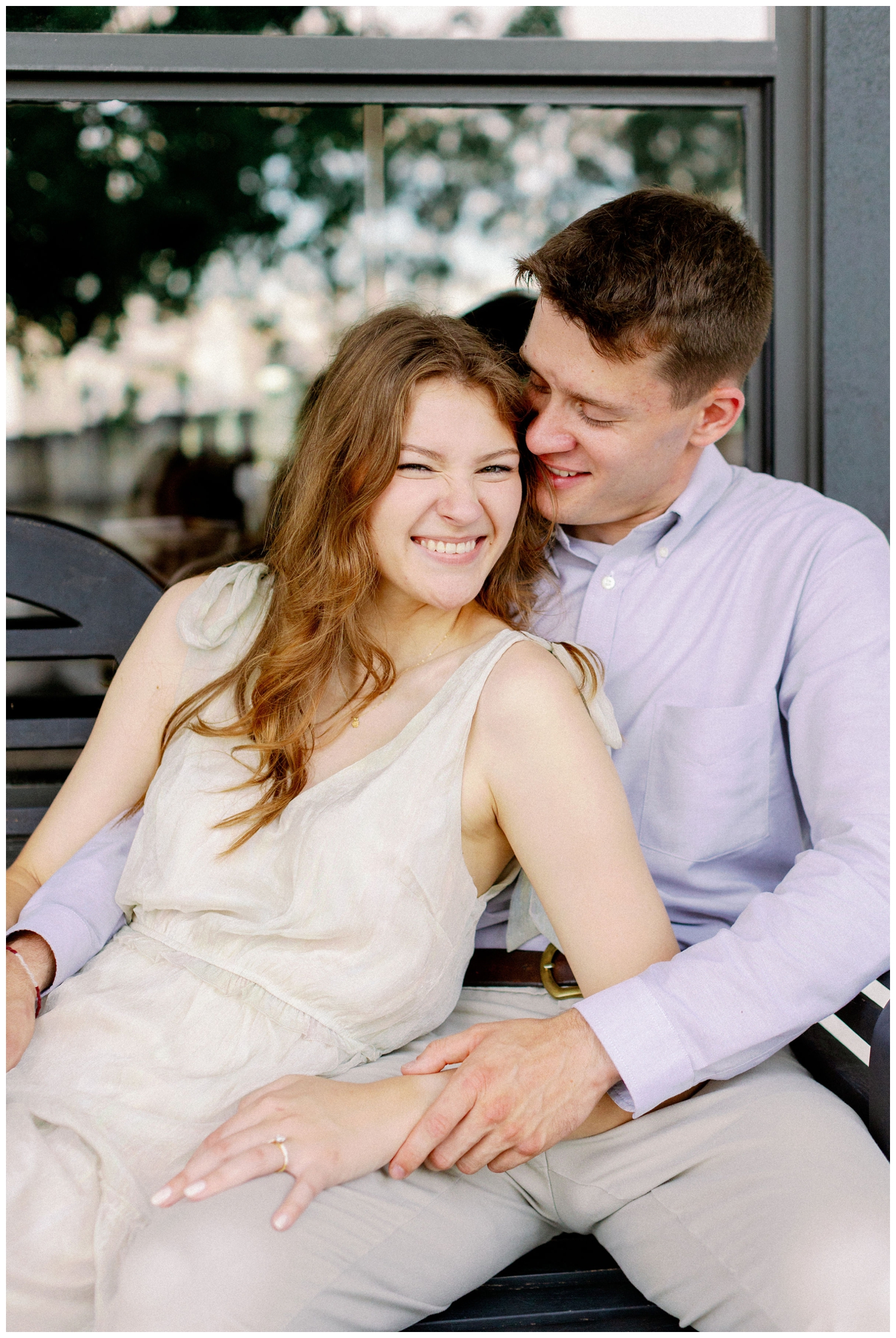 couple laughing and sitting on bench at Cy-Hope Cypress engagement photos