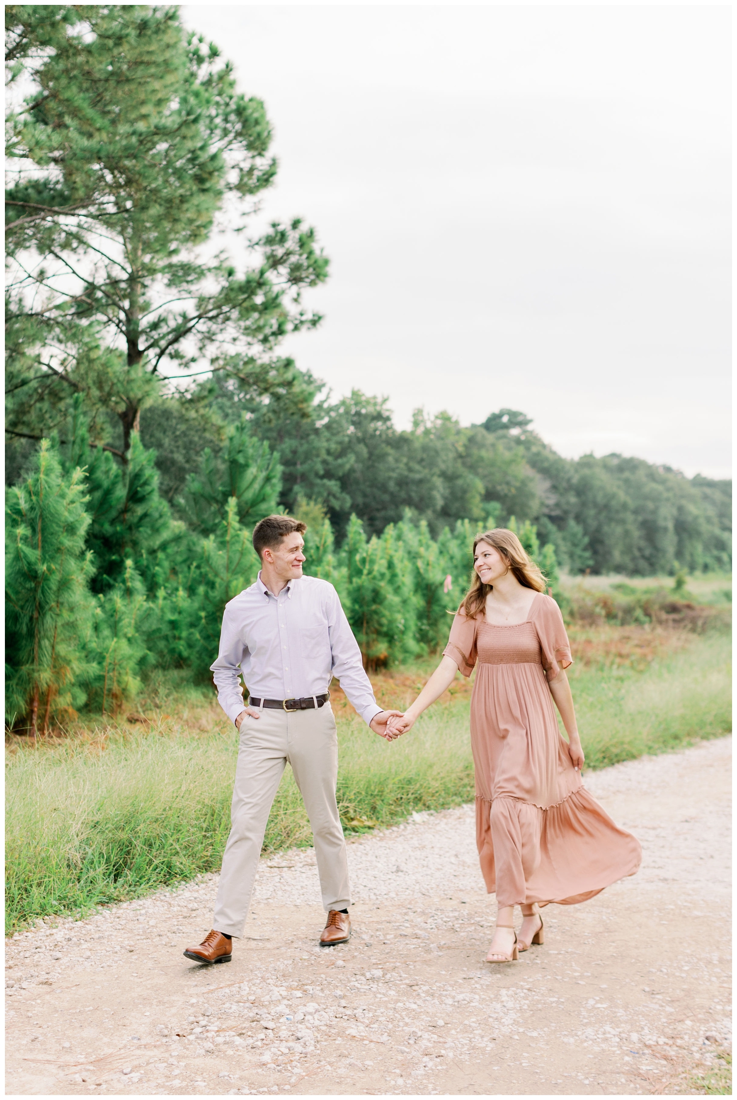 couple walking with bride in flowing coral dress