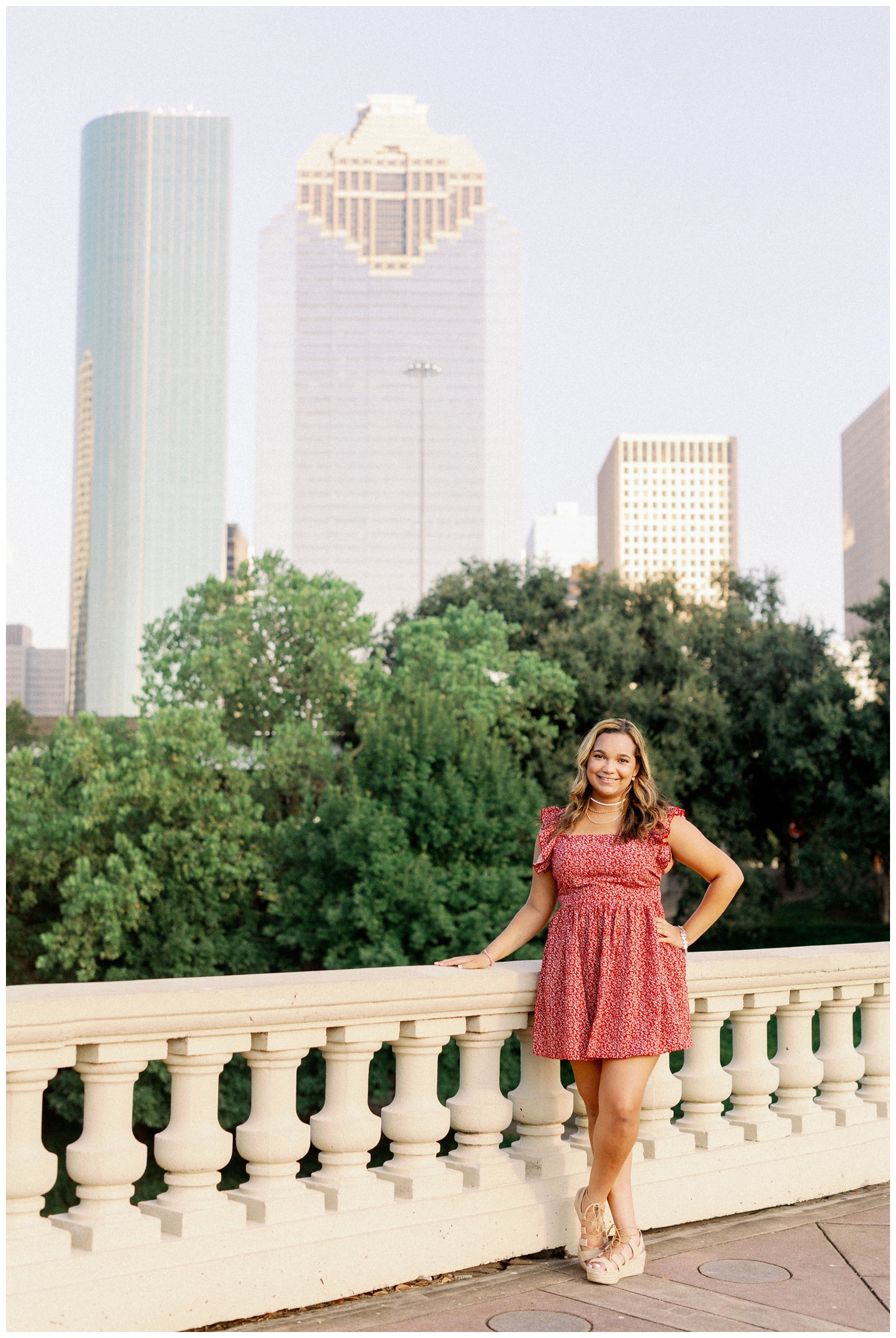 girl standing in front of Houston skyline on Sabine Street for Houston senior photos