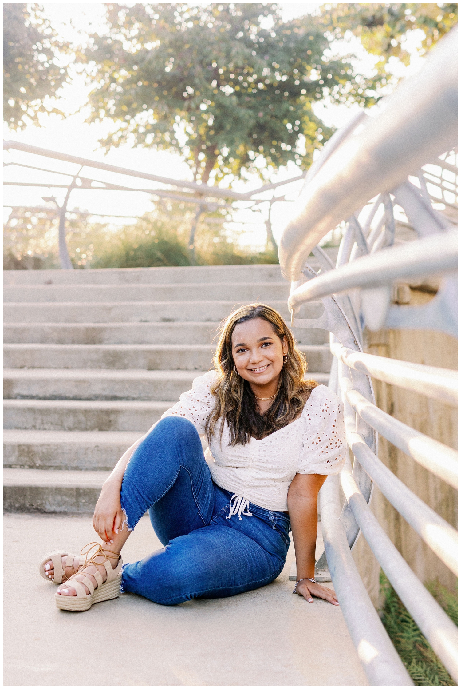 girl in white blouse and denim jeans sitting on staircase in Buffalo Bayou