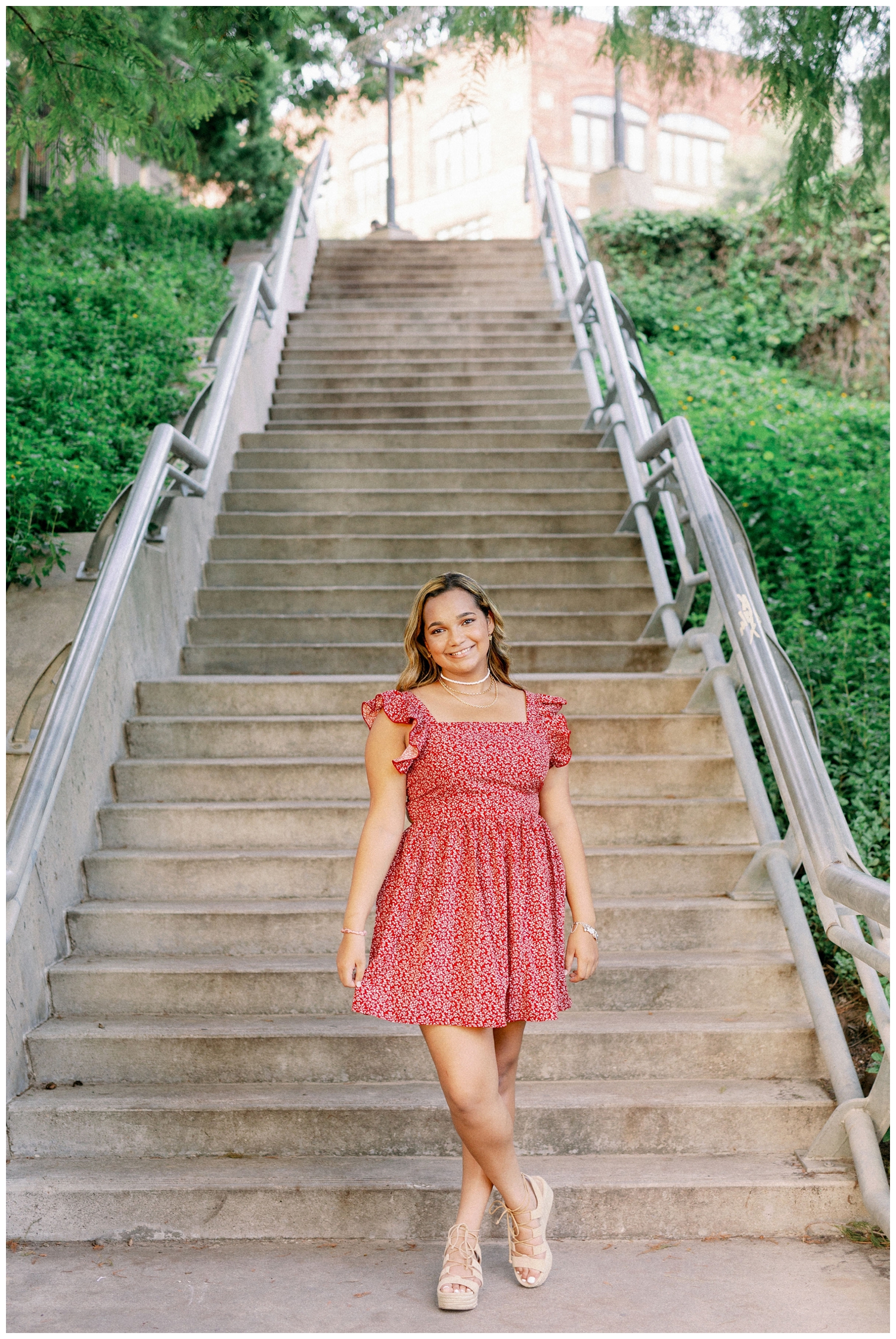 girl in floral dress standing at end of staircase