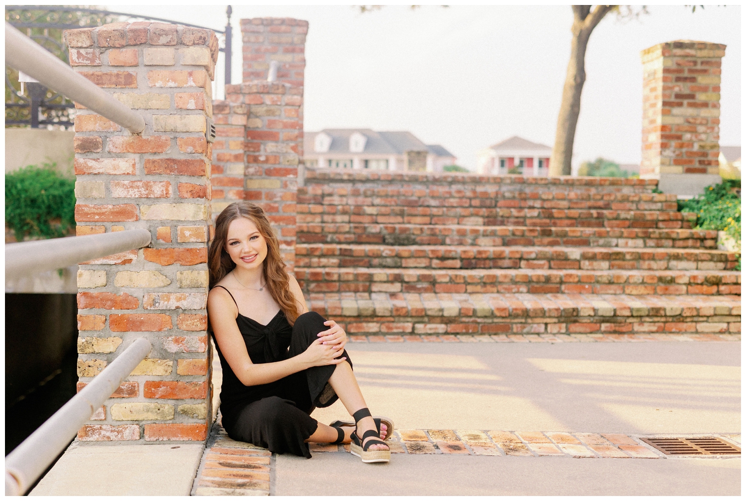 girl in black jumpsuit sitting on brick bridge in Galveston Texas