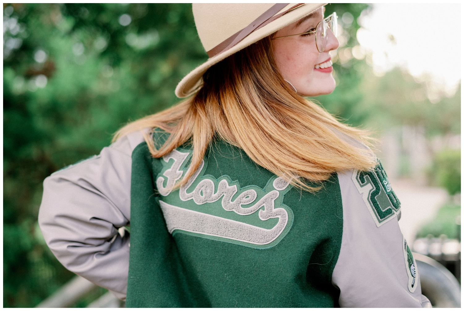 close up of senior girl with back of green letter jacket