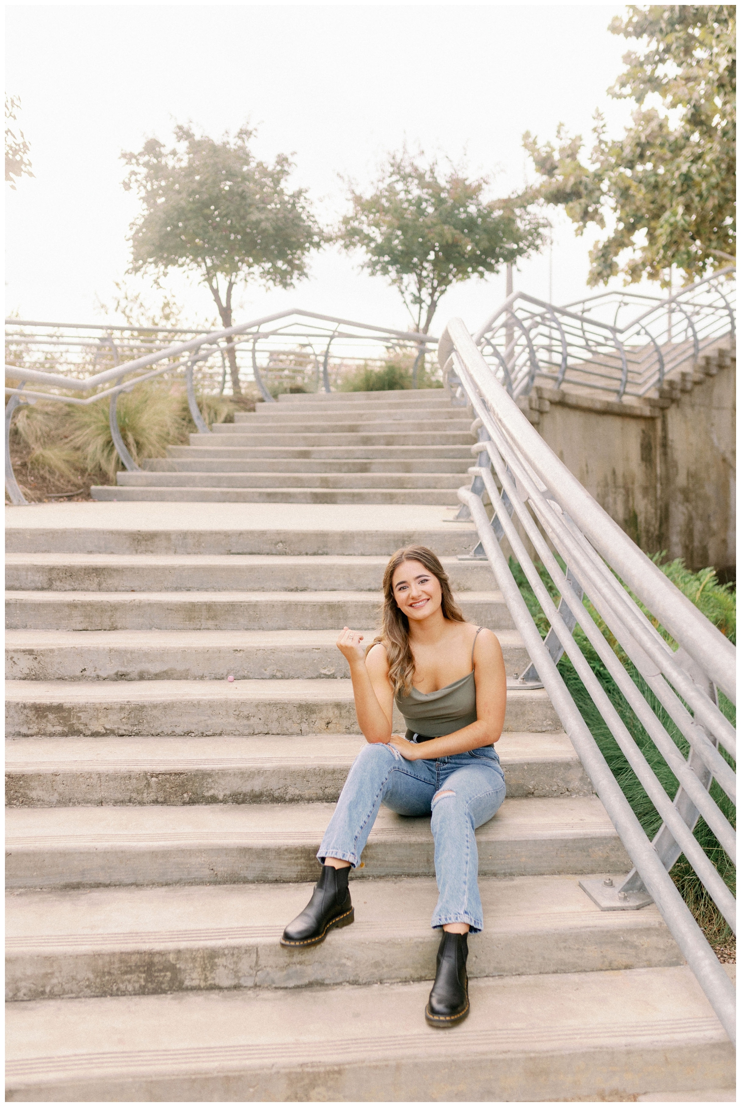 girl sitting on stair case with hand on her knee for Houston senior dance photographer