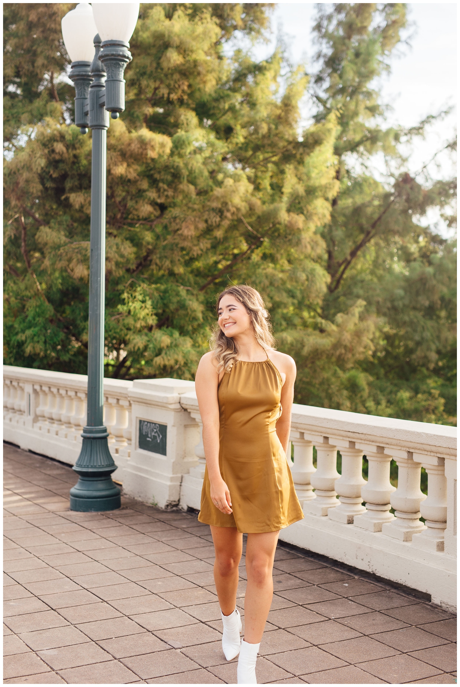 girl in gold dress and white boots walking on Sabine Street Bridge
