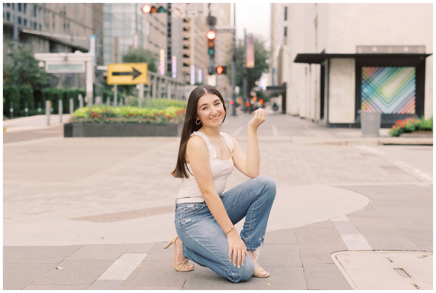 girl squatting on Main Street for Houston urban senior photographer