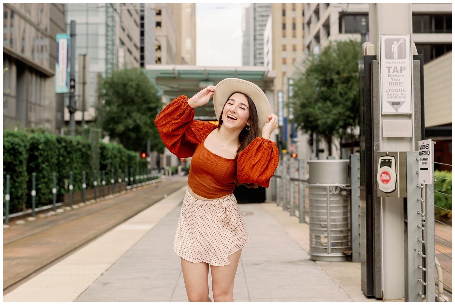girl standing holding hat on Main Street urban Houston