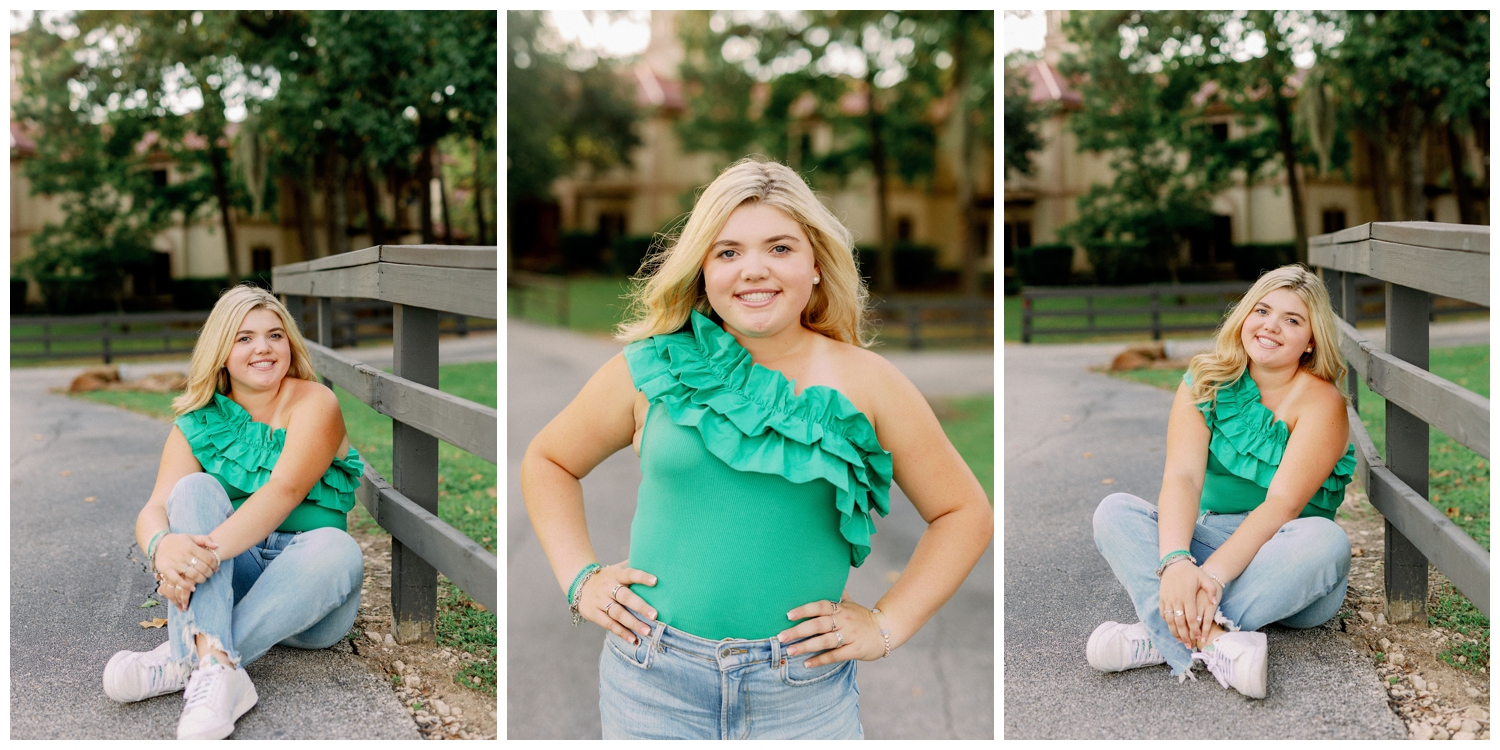 Houston senior in jeans and green shirt by rustic fence