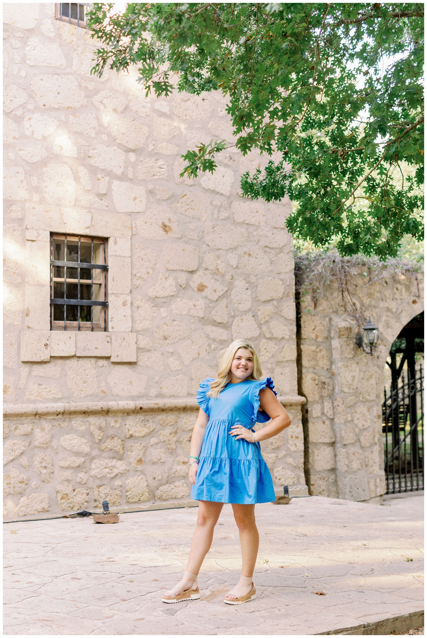 girl standing in blue dress in front of rustic building in Cypress, Texas