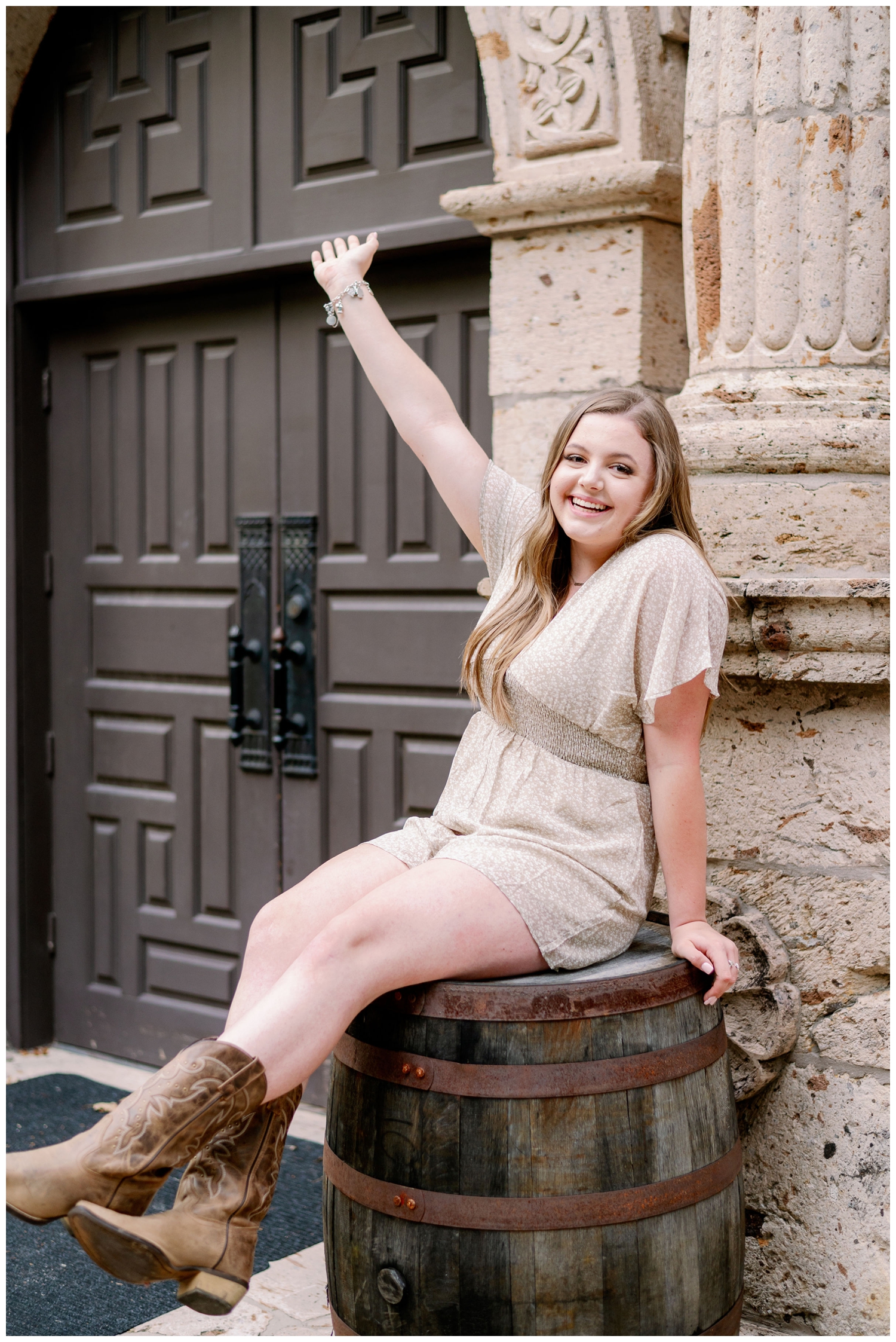 girl in romper with cowboy boots sitting on a barrel at Cy-Hope