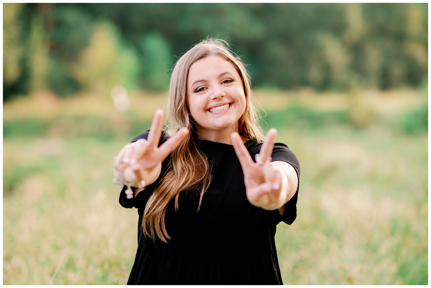 girl in black shirt holding Class of 2022 hand sign for Cypress senior photography at Cy-Hope