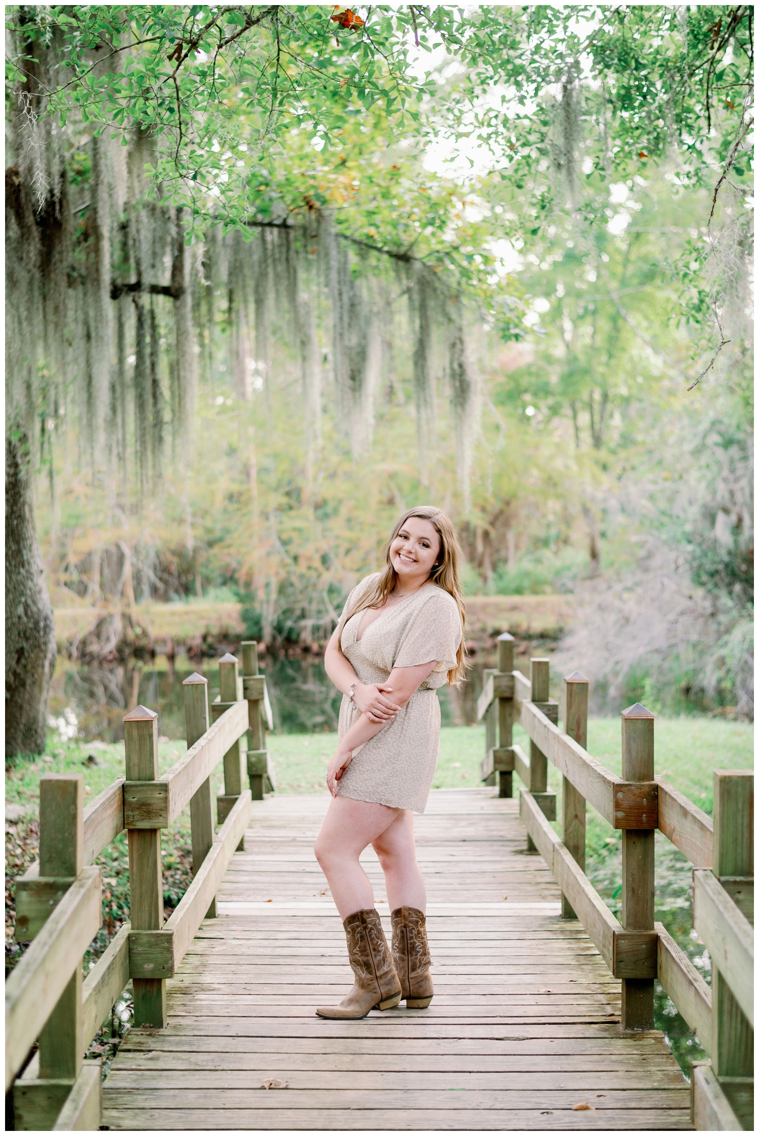 girl standing under mossy trees at Cy-Hope in romper and cowboy boots Cypress senior photography