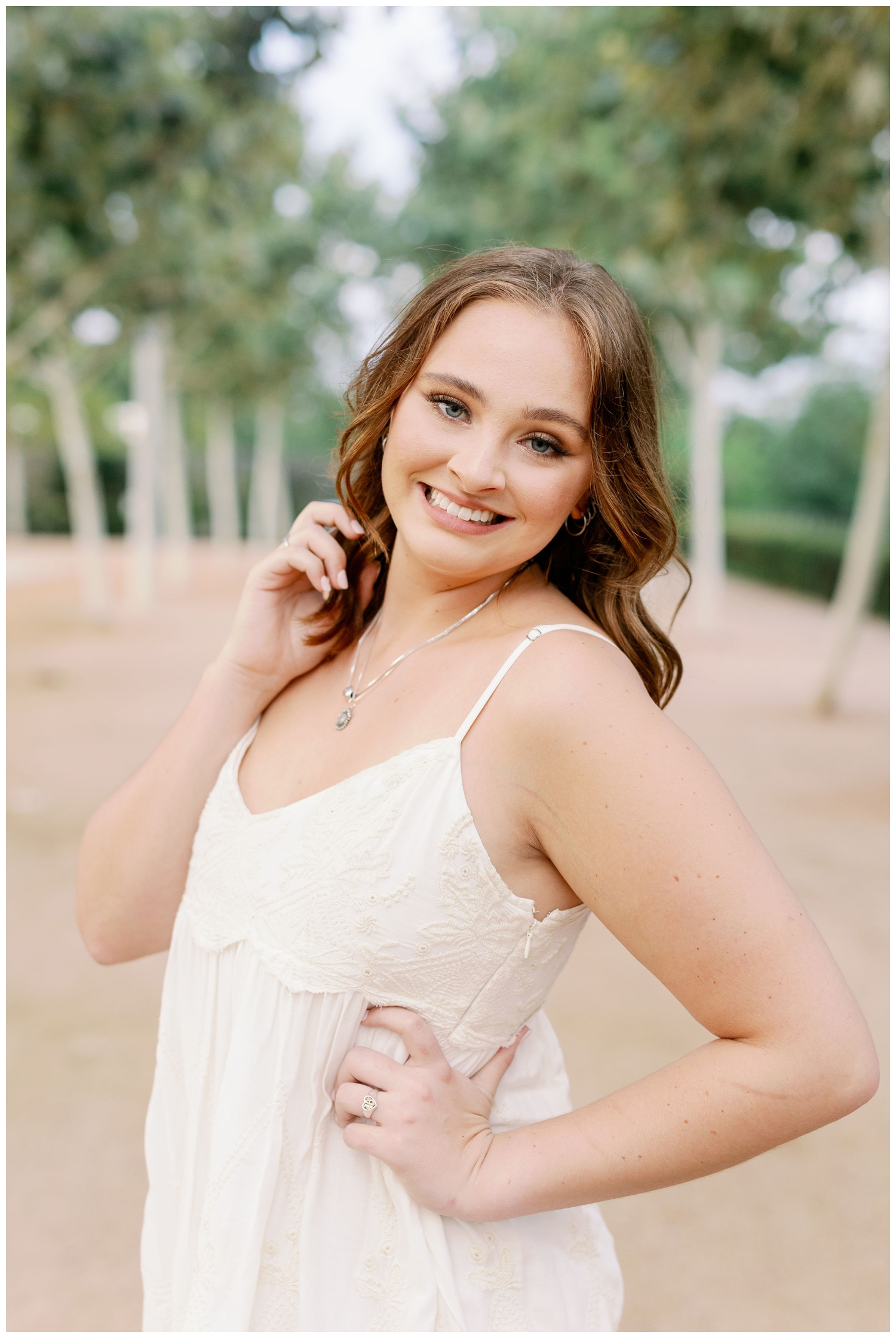Senior pictures in Houston girl smiling at camera white dress