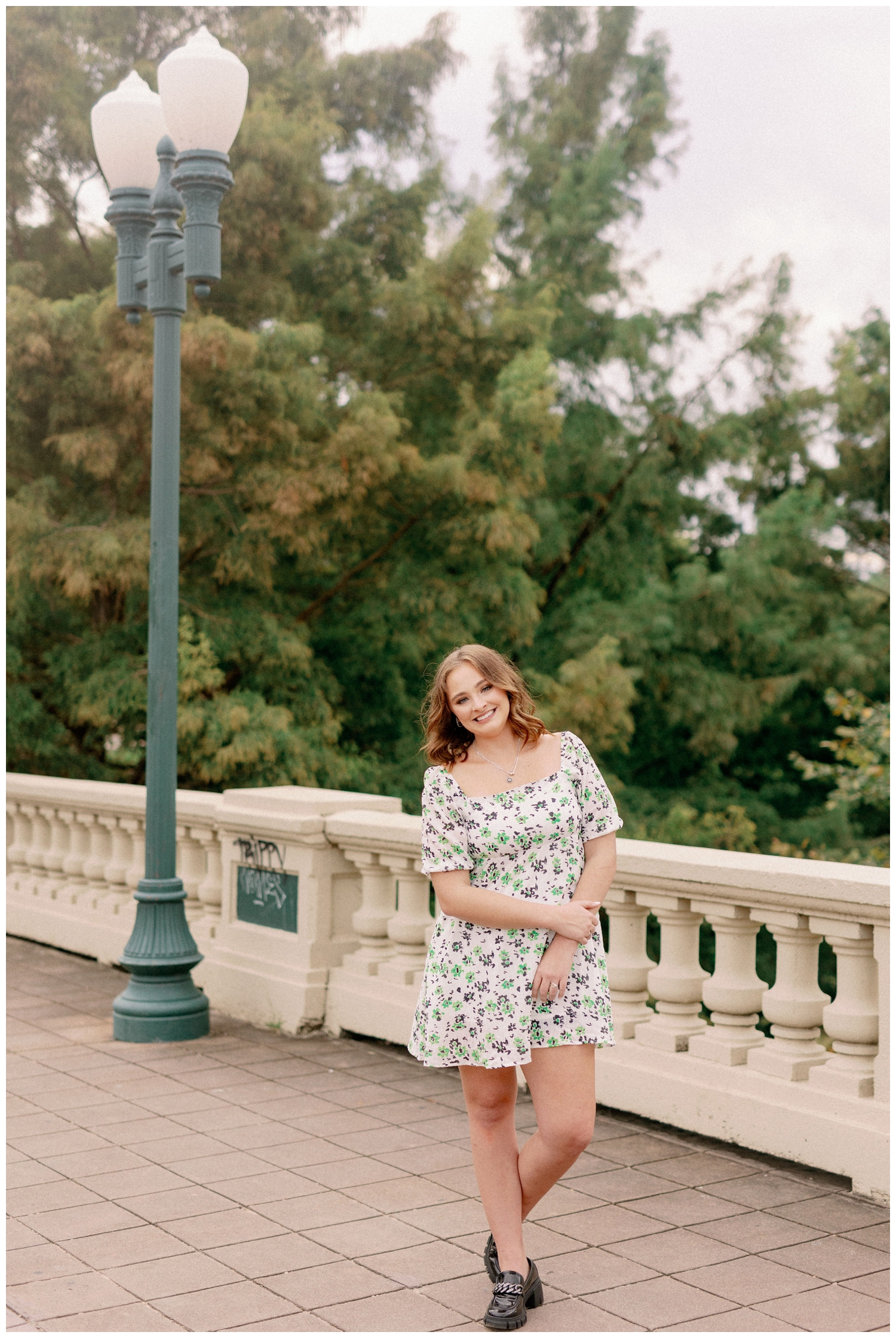 senior pictures in Houston with girl in colorful dress standing on Sabine Street Bridge